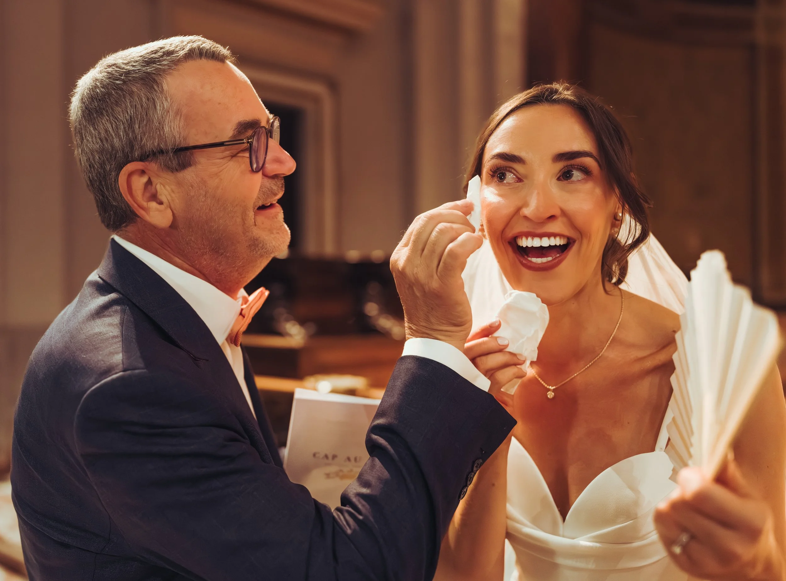 La mariée émue par sa cérémonie religieuse de mariage à l'église de Seysse, près de Toulouse, en Occitanie, est réconforté par son beau père. 