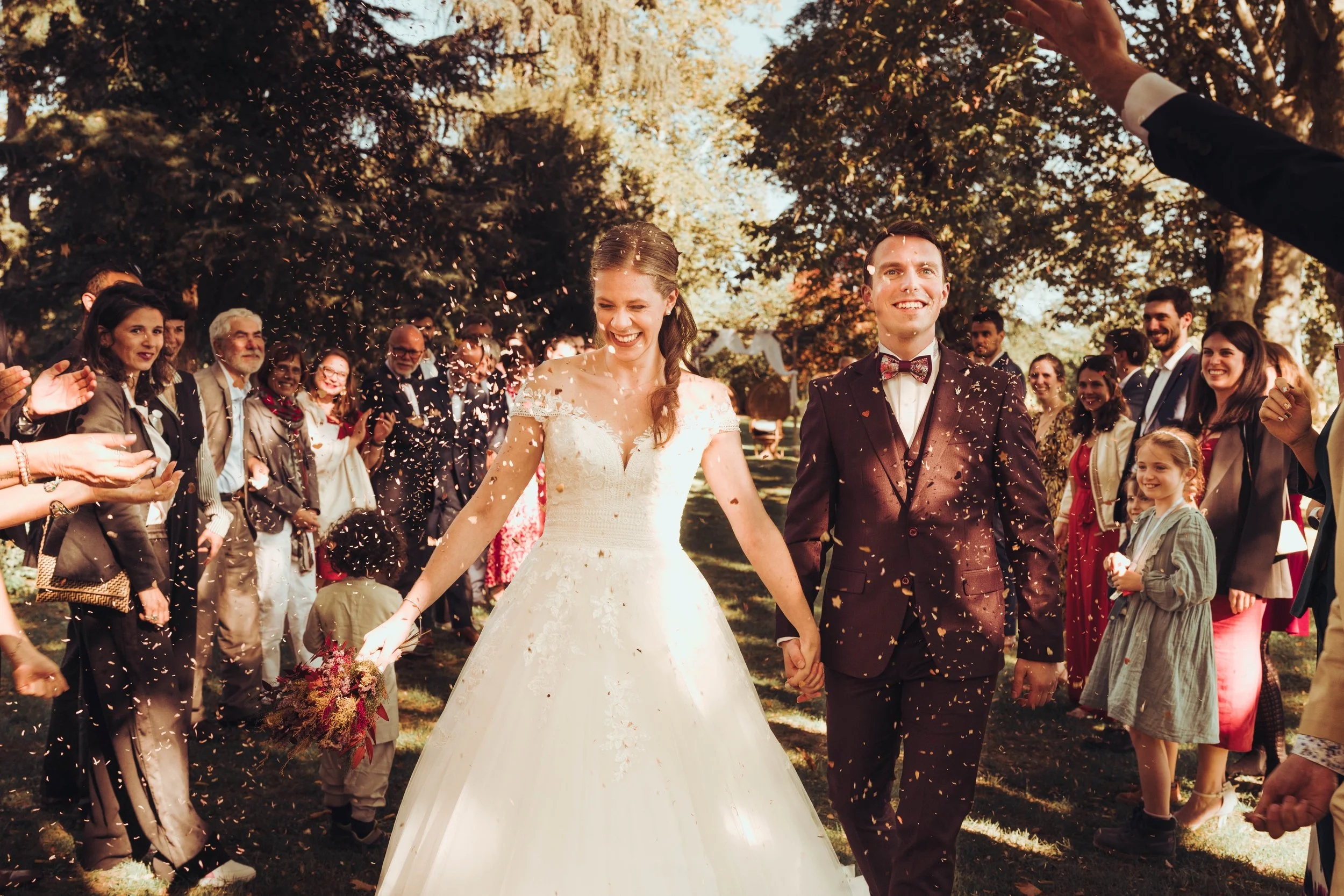 Haie d'honneur autour des mariés à la sortie de leur cérémonie laïque dans les jardins du manoir du Thouron près de Toulouse, en Occitanie. 