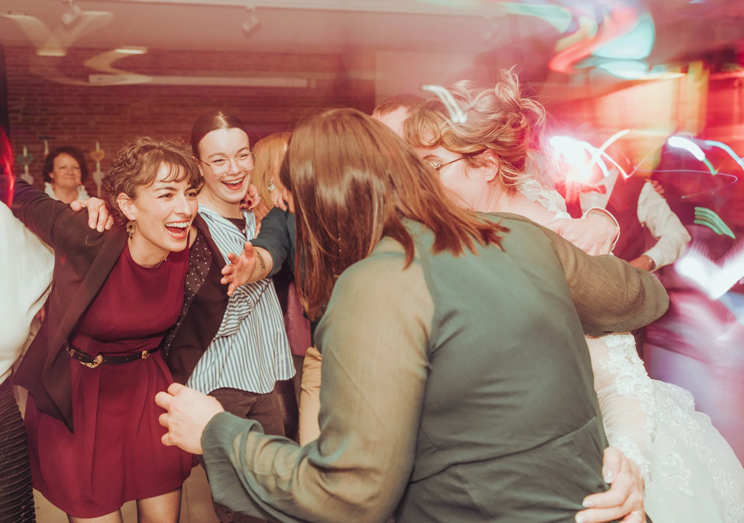 Groupe de personnes souriantes lors d'un mariage au Domaine de Montjoie, avec effets de lumière en lightpainting