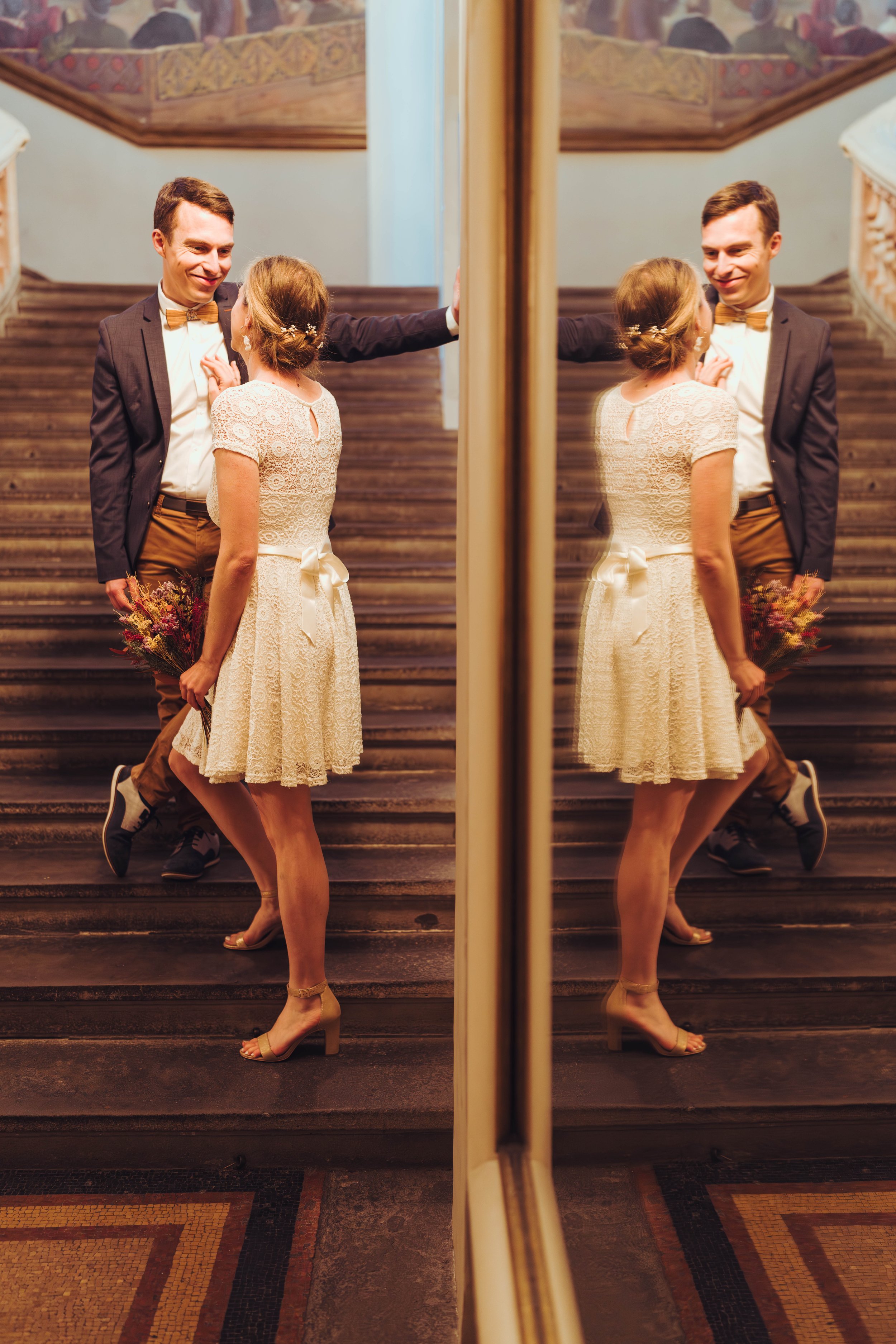 Jeune couple marié au Capitole de Toulouse se regarde dans les escaliers avant de se rendre à son mariage dans la salles des Illustres. 