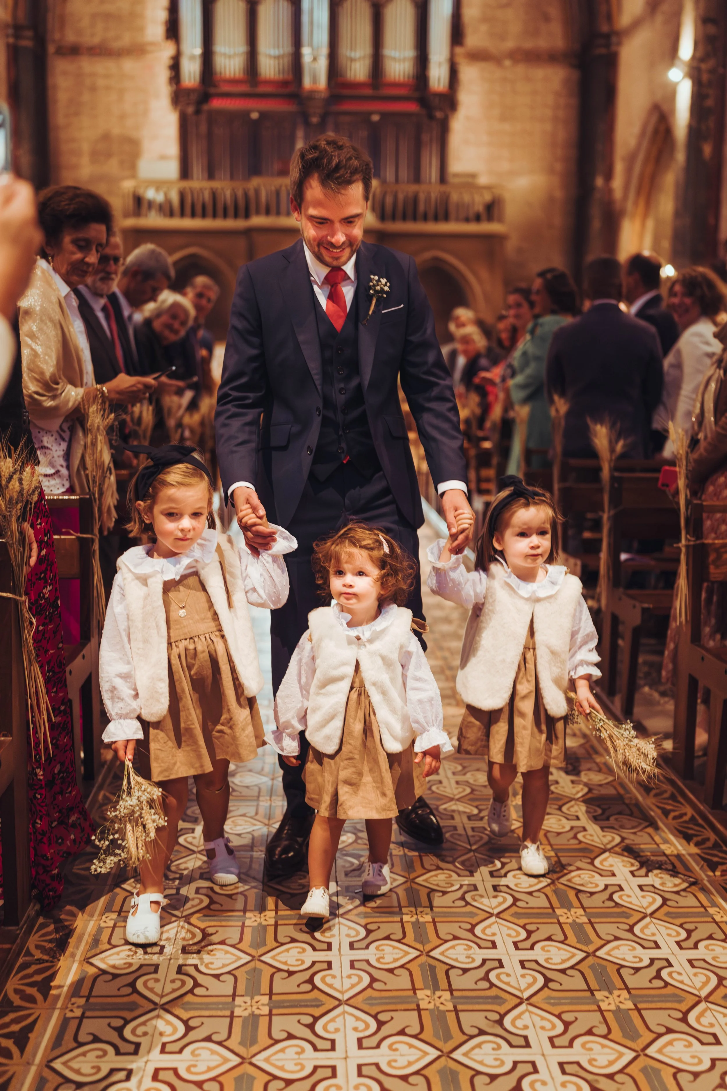 Le futur marié rentre à l'Eglise avec ses petites filles d'honneur proche de Gaillac