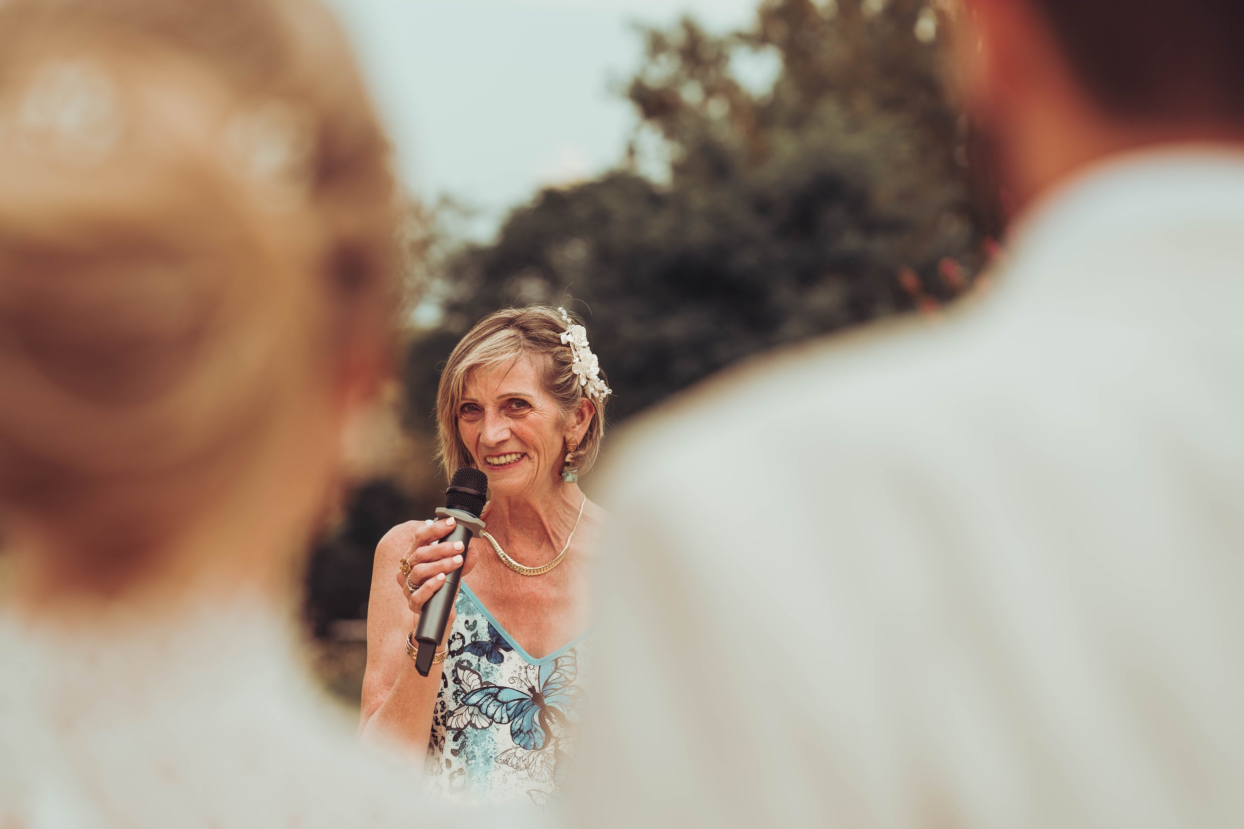 La mère du marié fait un discours lors de la cérémonie de mariage en extérieur proche de Toulouse. 