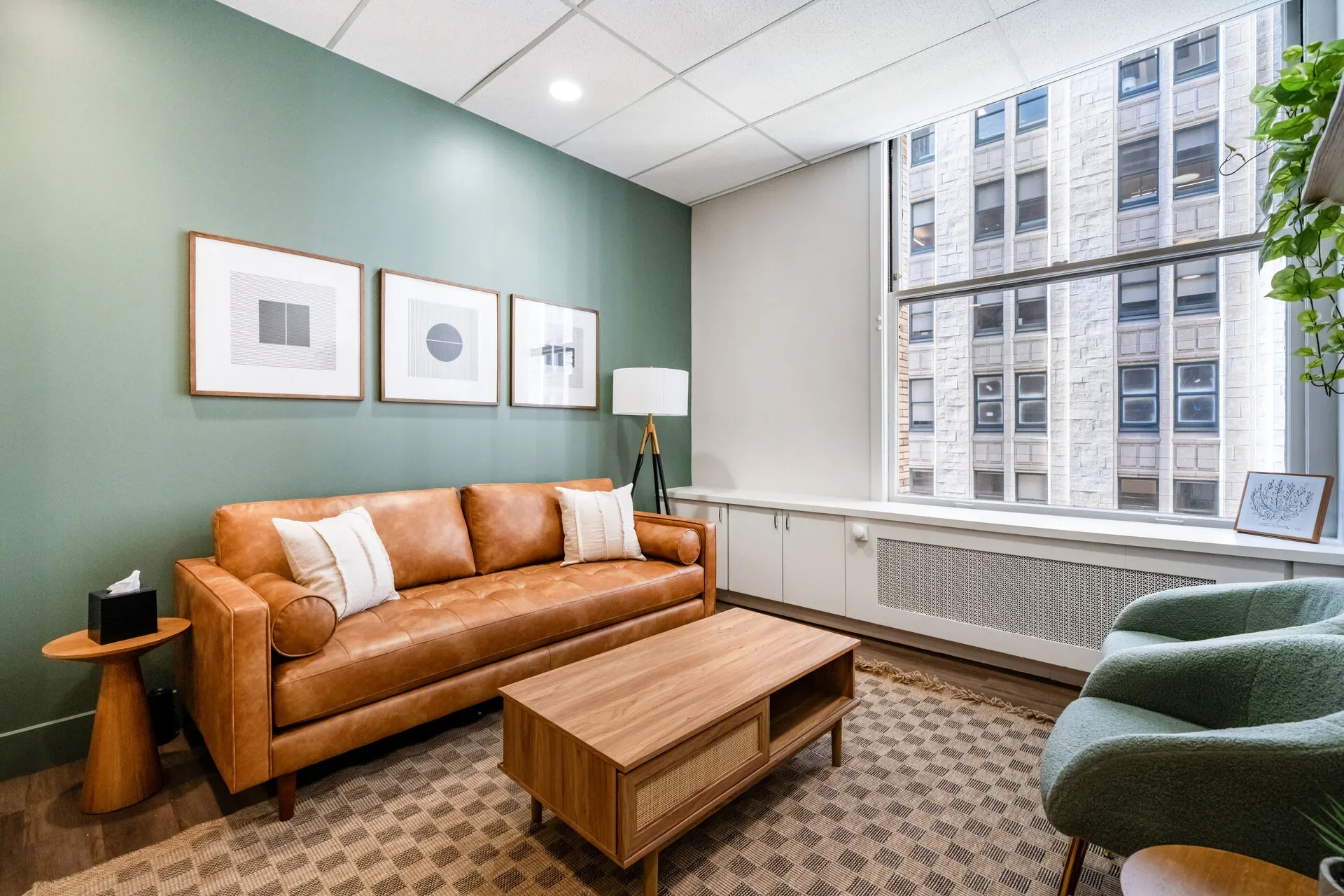 Therapy office in San Francisco with leather sofa and sage green walls