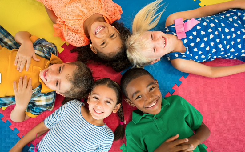 young kids laying down in a circle