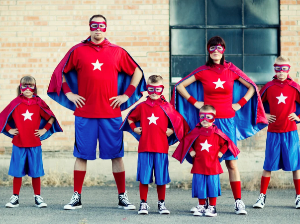 Family standing dressed as super heros