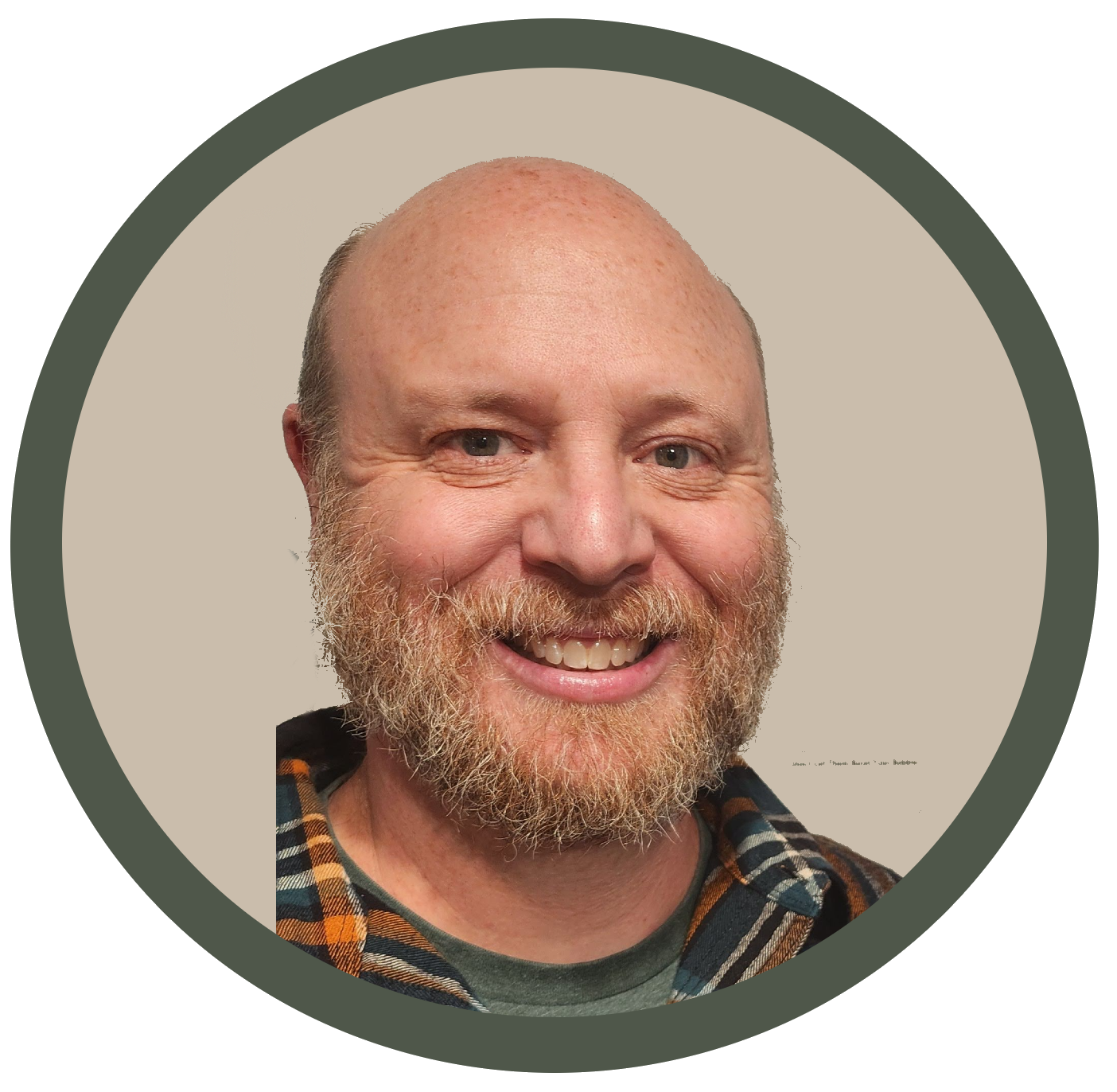 A smiling man with a bald head and a full beard, wearing a plaid shirt.