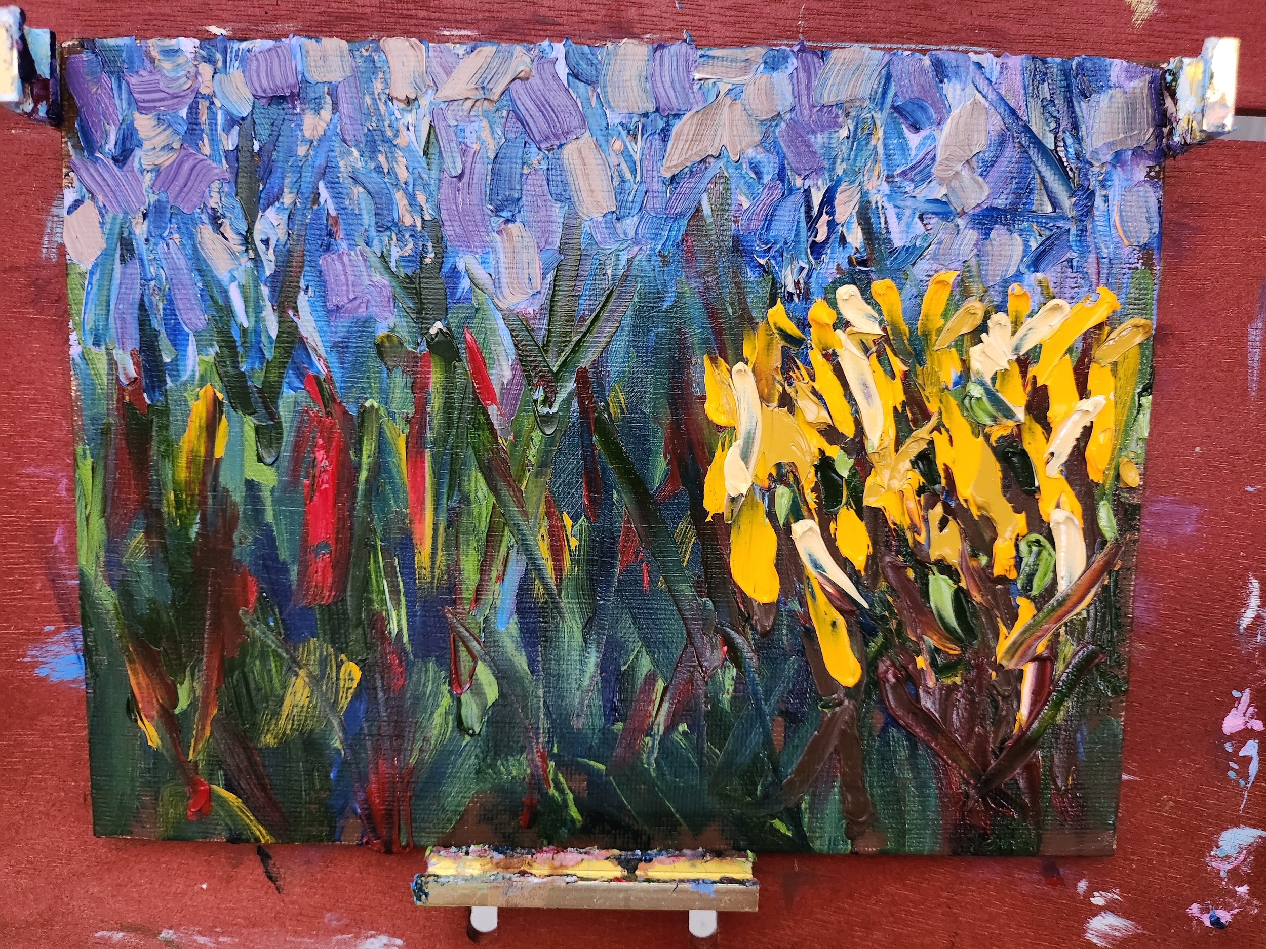 An abstract impressionist-style oil painting of purple and yellow irises with green stems, created with thick, textured brush strokes on a canvas.