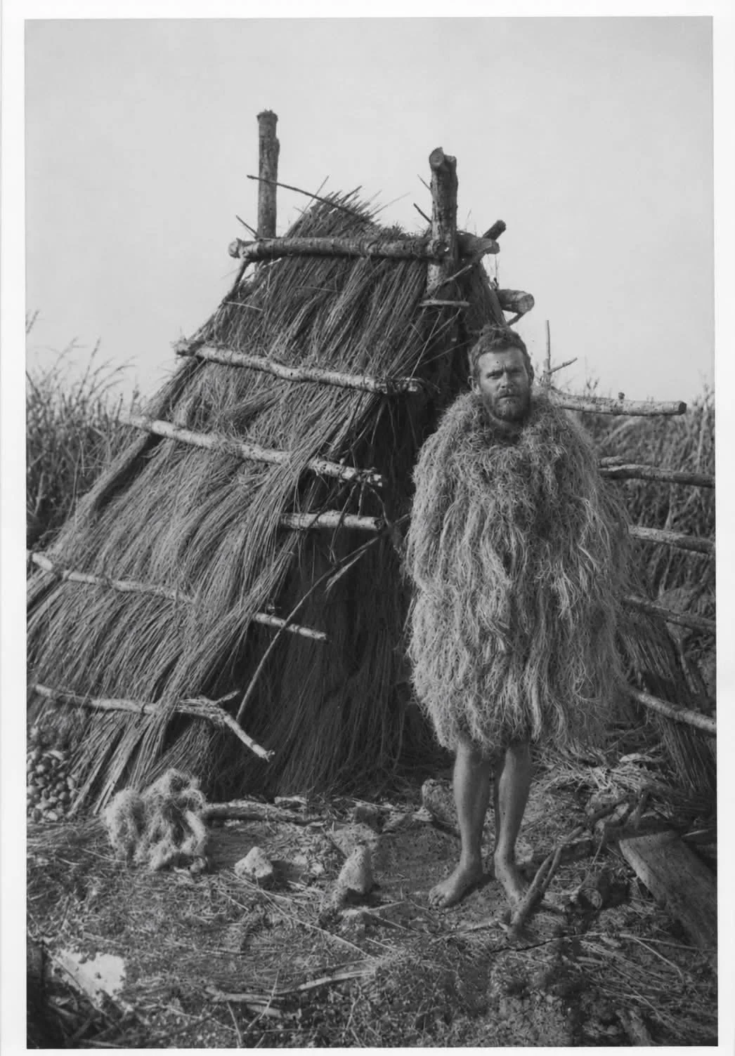 'Wild Bill' Belvin shown in a ghillie suit in front of an A-frame chickee hut.