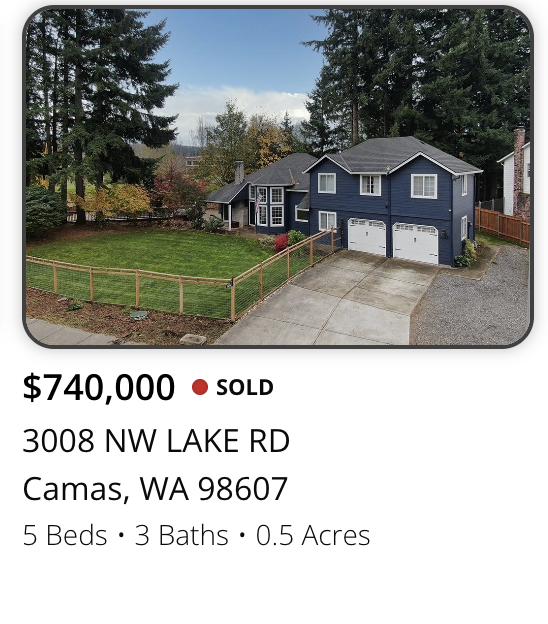 A two-story blue house with a detached garage, surrounded by a fenced grassy yard and tall trees, located at 3008 NW Lake Rd, Camas, Washington, listed for $740,000, recently sold, with 5 bedrooms and 3 bathrooms on 0.5 acres.