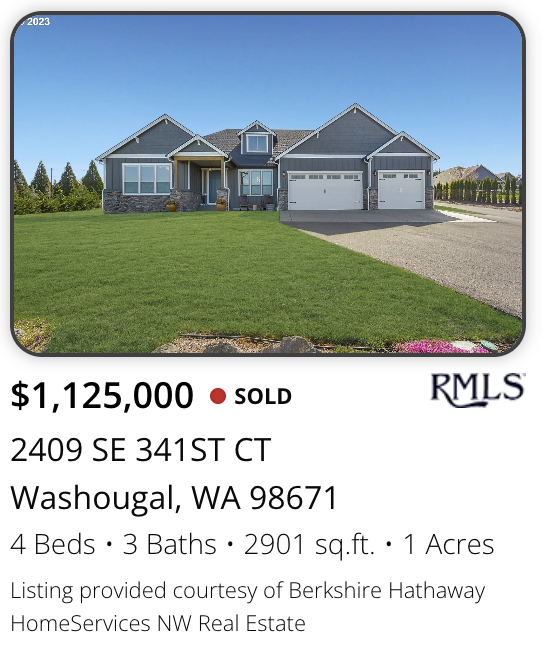 A Washougal home sold on 1 acre by realtor Kelly Craig Graham. Front view of a suburban house with a gray exterior, two garages, a well-maintained lawn, and a blue sky.