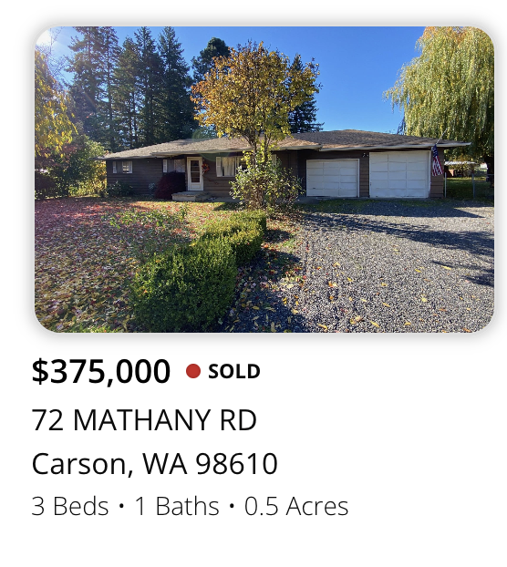 Single-story house with a garage, surrounded by trees and a gravel driveway, located at 72 Mathany Rd, Carson, WA.