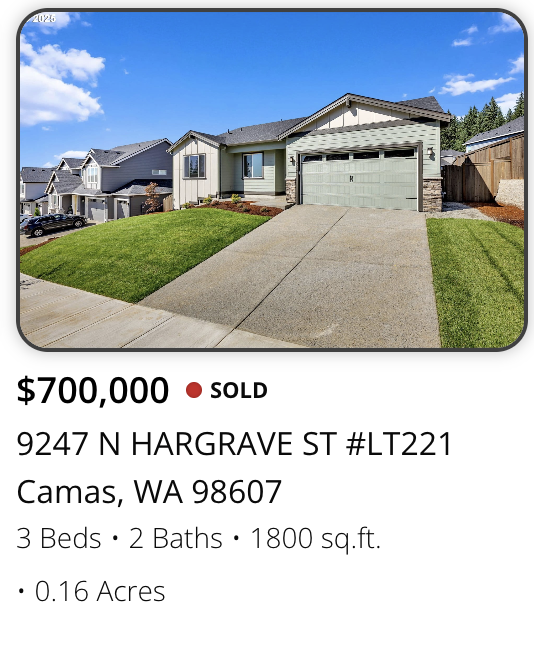 Front view of a house with a driveway, surrounded by a well-maintained lawn, in Camas, Washington, listed for sale at $700,000.