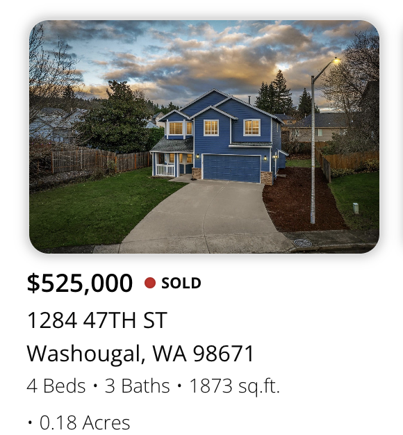 Blue two-story house with a driveway, front yard, and fenced backyard, under a cloudy sky at sunset.