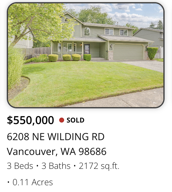 Front view of a two-story house with green siding, a gray roof, well-maintained lawn, and a driveway, in Vancouver, Washington.