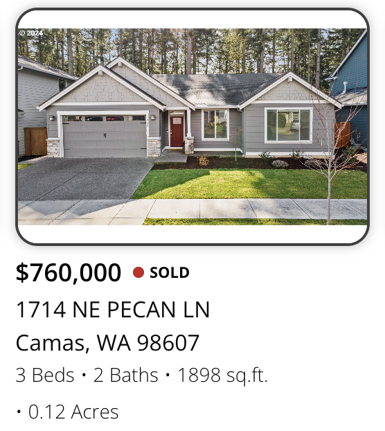 Photo of a single-story house with gray siding, white trim, and a gray roof, with a garage and small front yard in Camas, Washington.