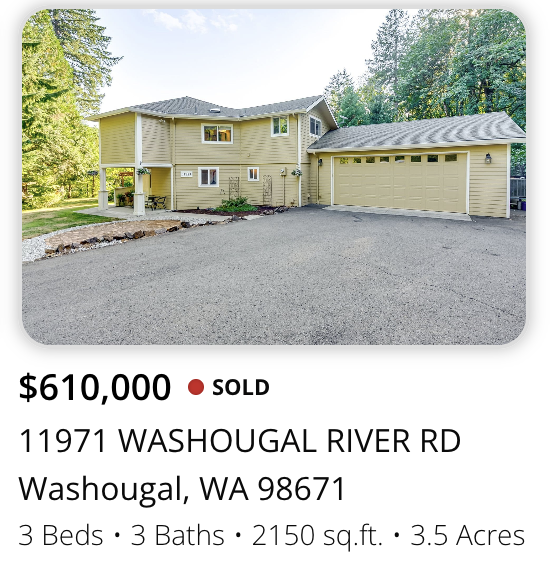 Front view of a yellow, two-story house with attached garage on a 3.5-acre property, with trees surrounding it.