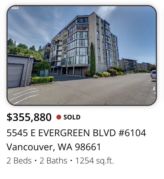 Modern multi-story apartment building with glass balconies and landscaped surroundings in Vancouver, Washington.