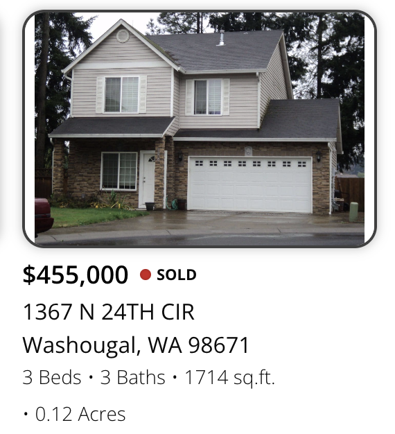 Front view of a two-story house with a brick and beige siding exterior, a two-car garage, and a driveway in Washougal, Washington.