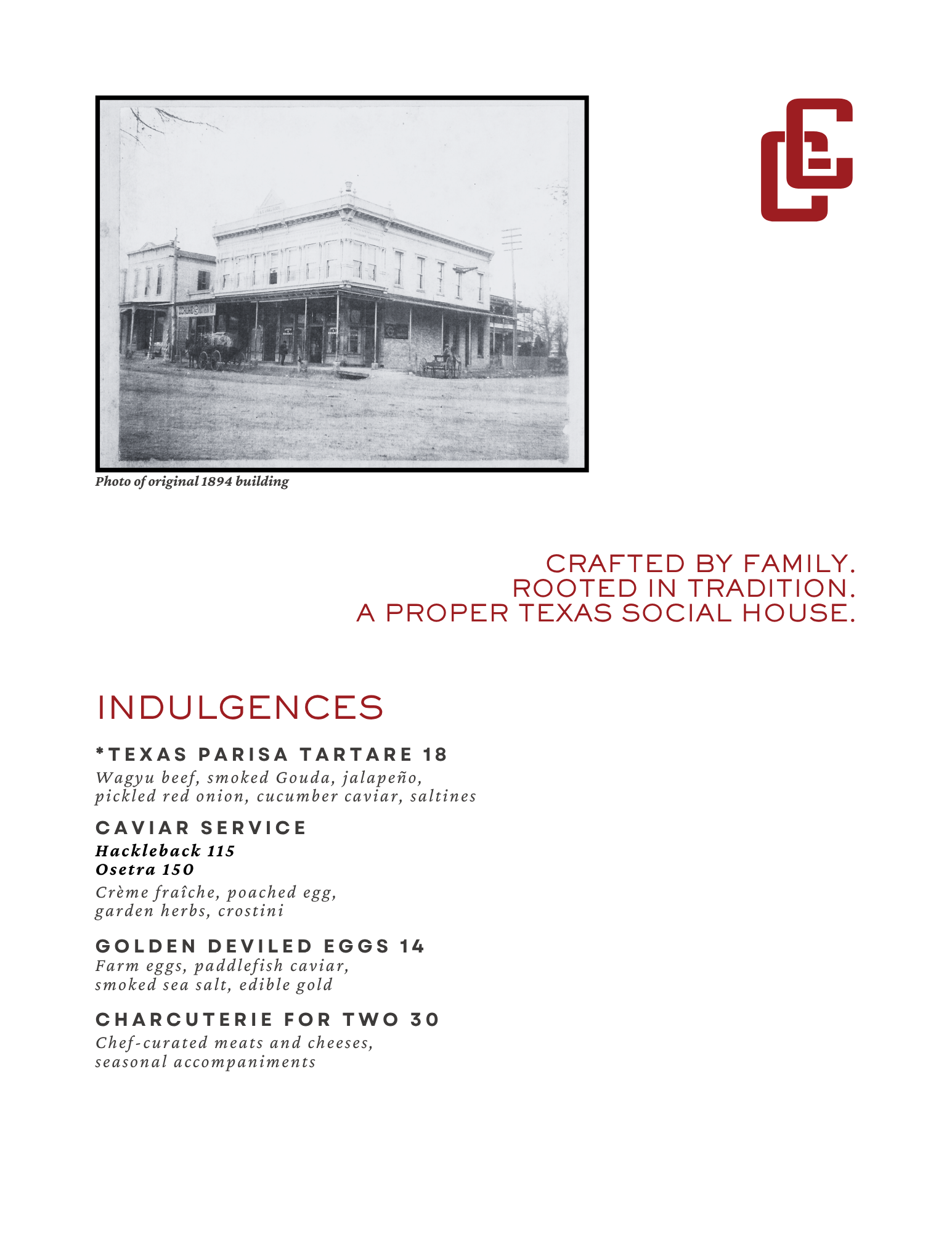 Black and white photograph of a historic two-story building from 1894. The building has a corner porch and multiple windows, with a vintage car parked outside.