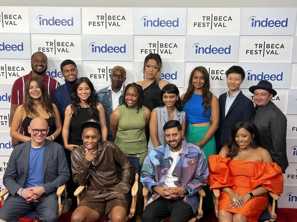Group of diverse individuals posing together at a media event, with a backdrop displaying logos for 'Indeed' and 'Tribeca Film Festival'.