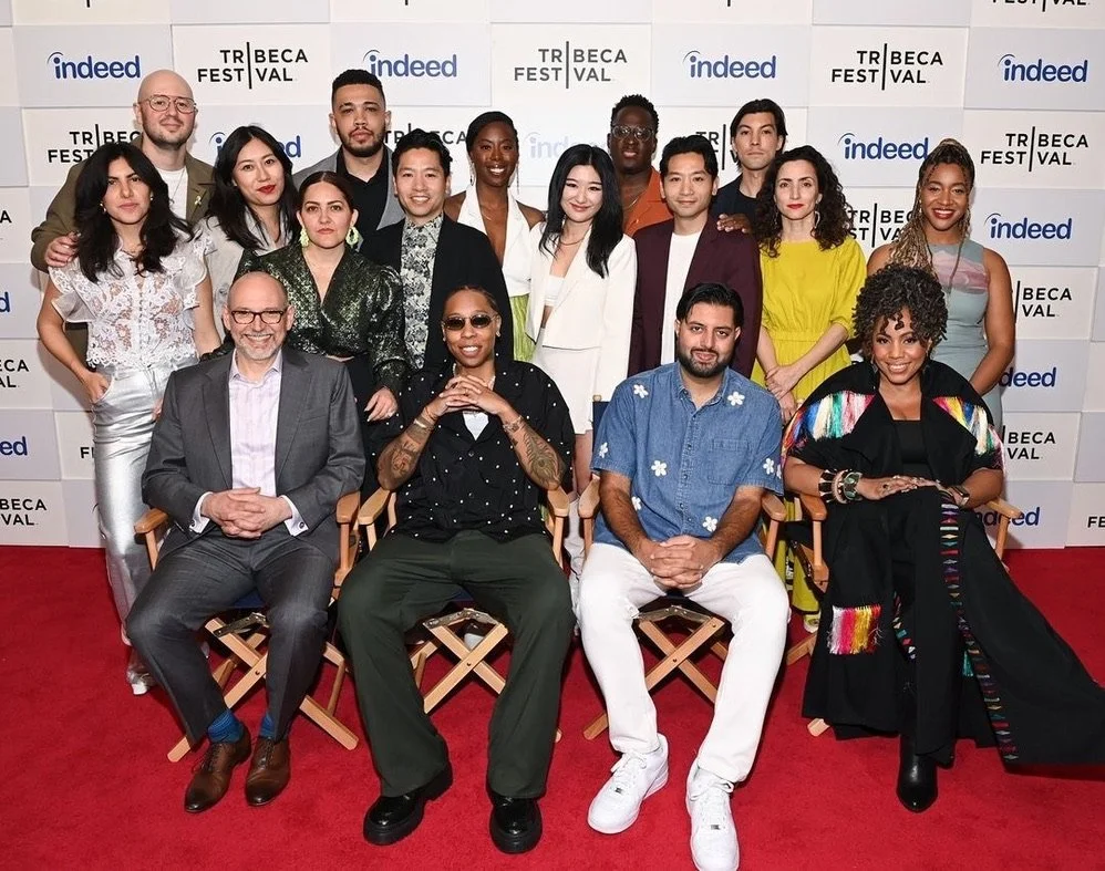 Group photo of diverse people at a film festival event with a backdrop displaying logos for Indeed and Tribeca Festival.