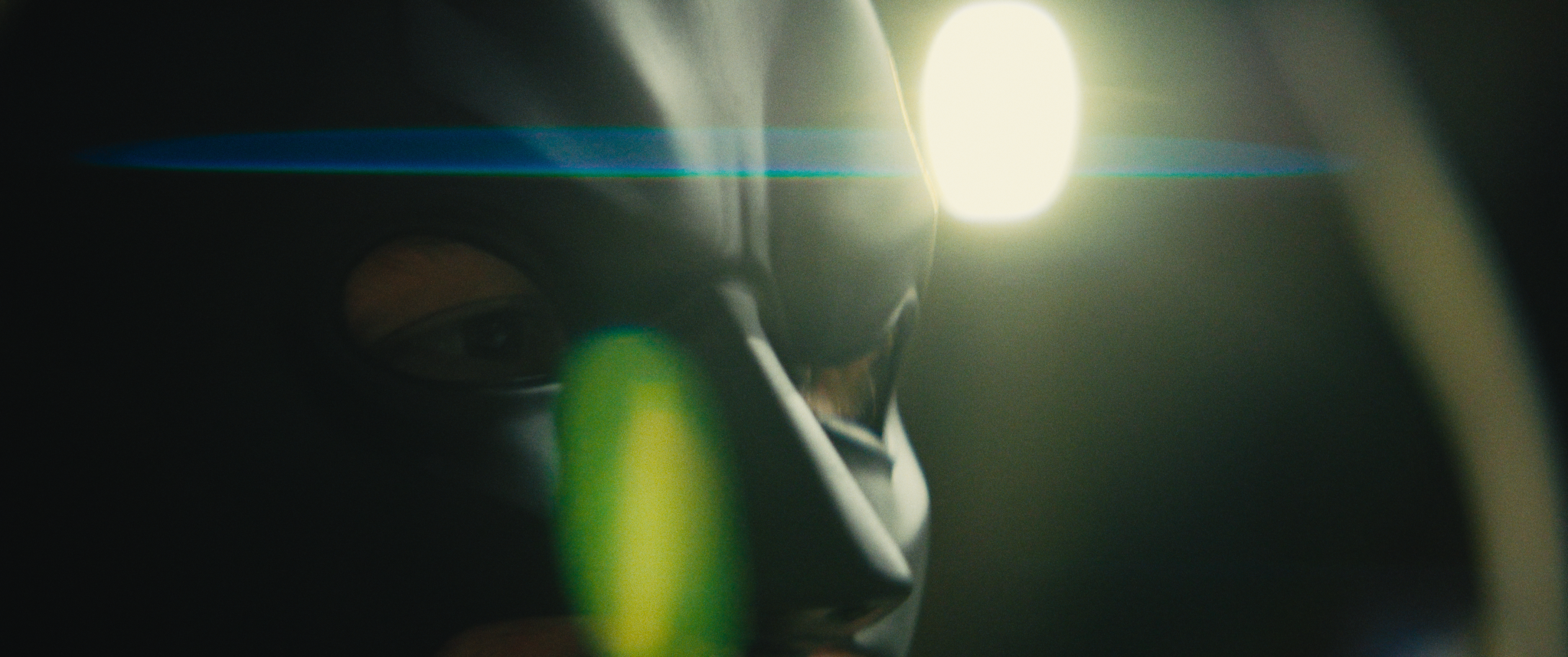 Close-up of a person with light shining behind their head, creating a lens flare.