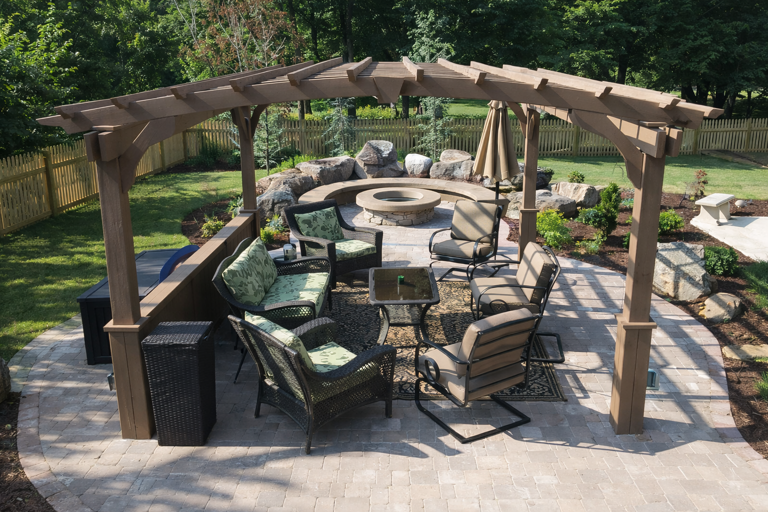 An outdoor patio with a wooden pergola, seating area with chairs and a table, a fire pit surrounded by rocks, and a garden with trees and plants.