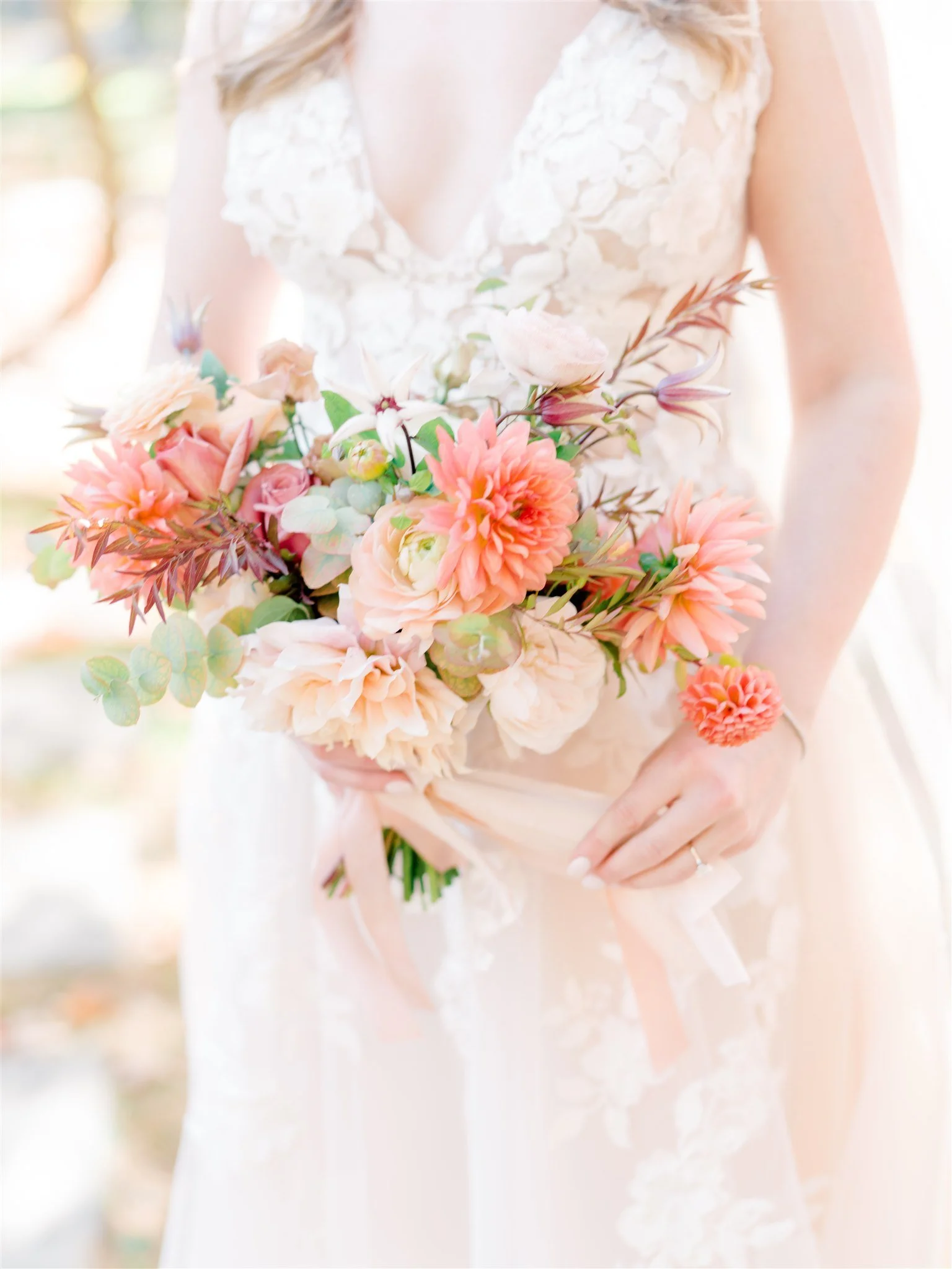 A woman in a wedding dress holding a pastel-colored bouquet of flowers.