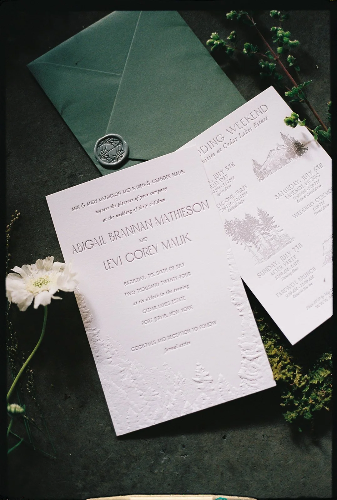 Wedding invitation and event details, with a green envelope sealed with a wax stamp, accompanied by floral and greenery decorations.