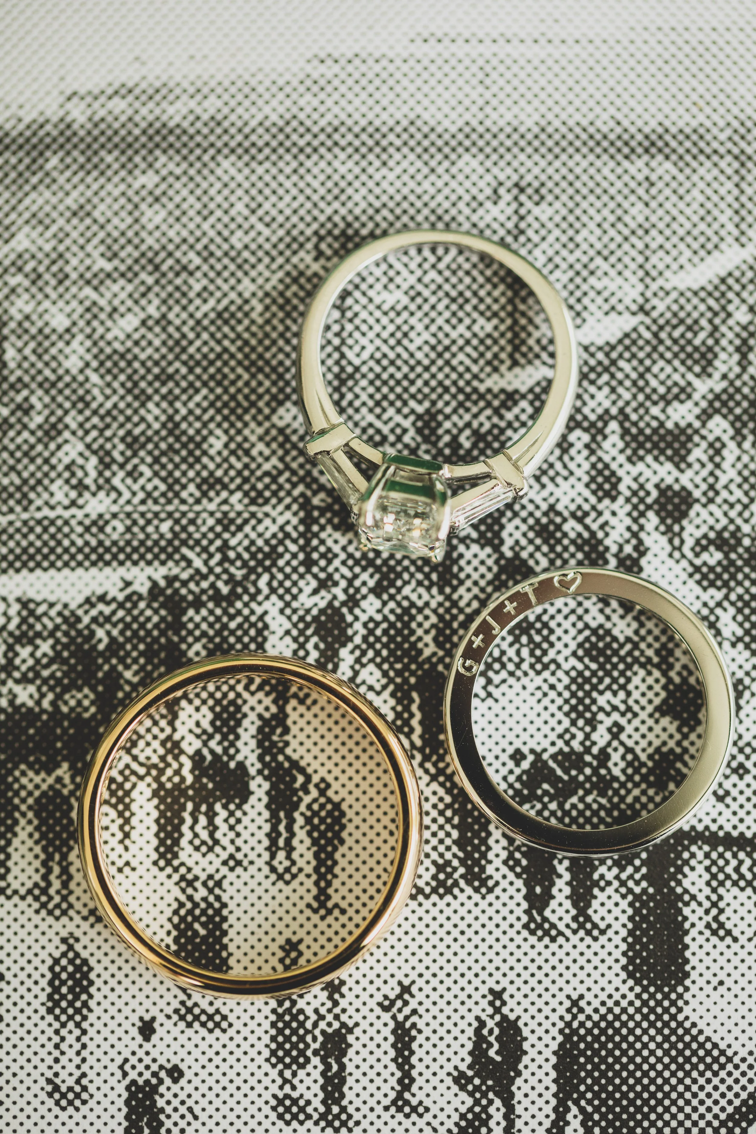 Three rings placed on a black and white patterned fabric.