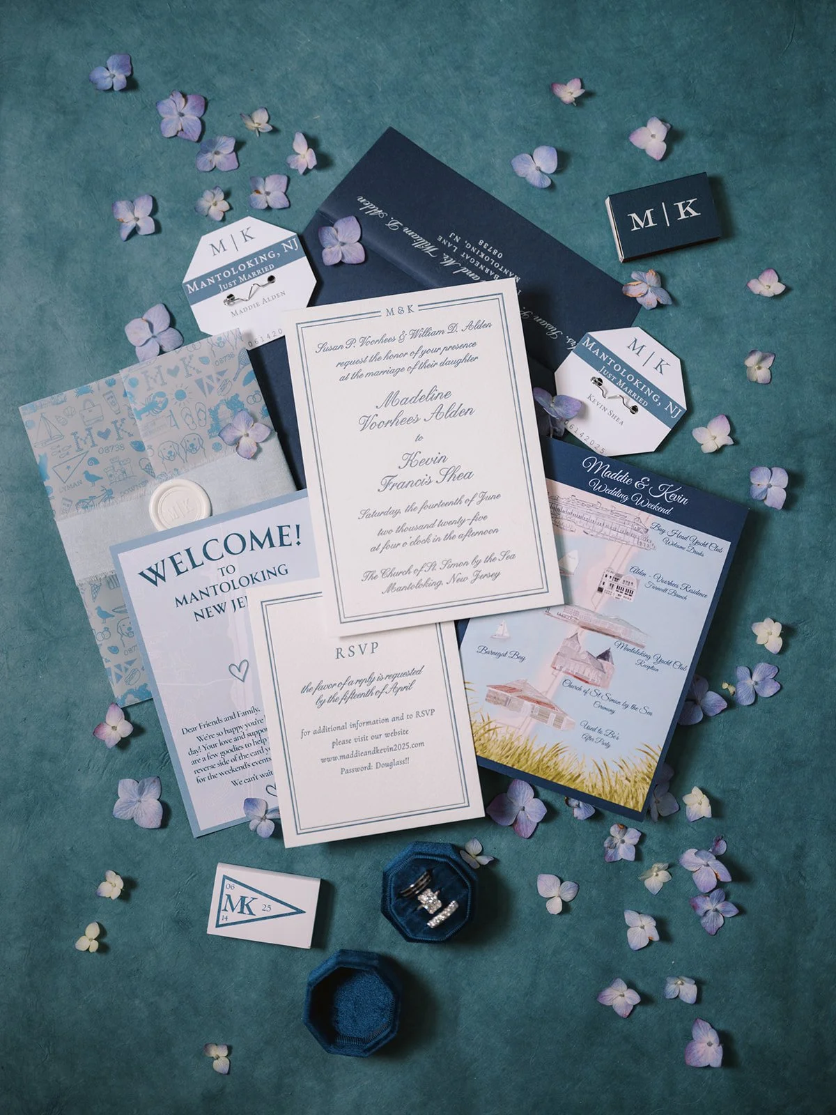 Wedding invitation suite with RSVP card, welcome letter, and name tags, decorated with lavender-colored flowers and set against a teal background.