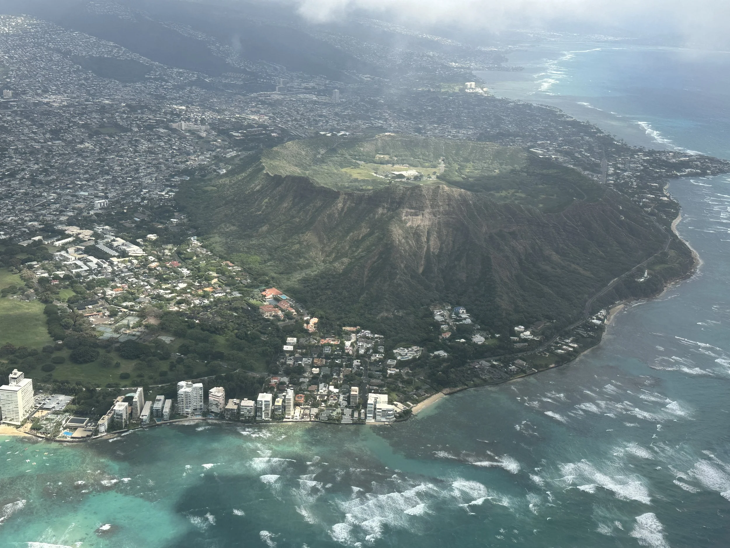 Aerial view of coastal city with mountains, urban area, and ocean