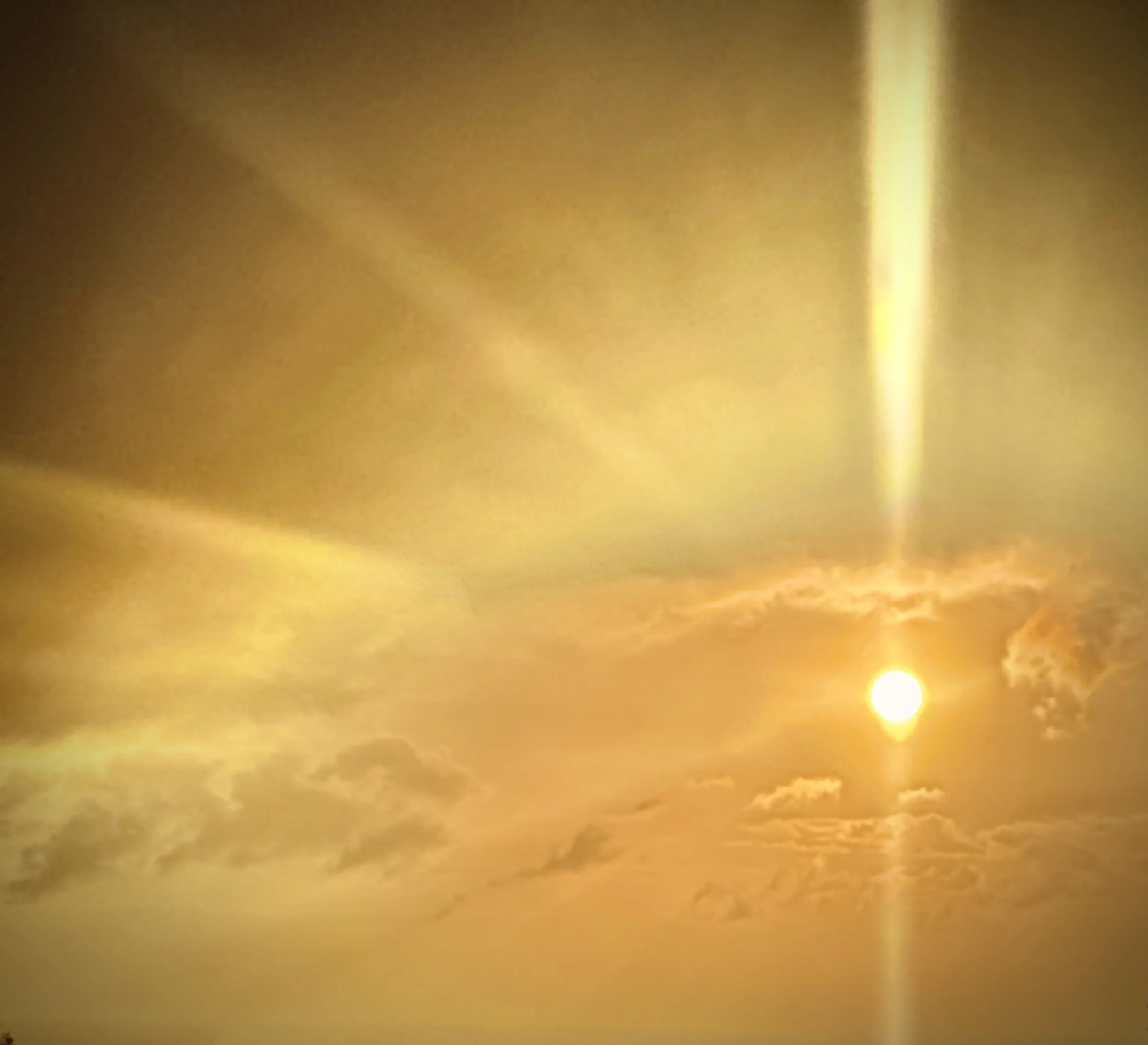 Blurred golden sky with clouds and sunlight.