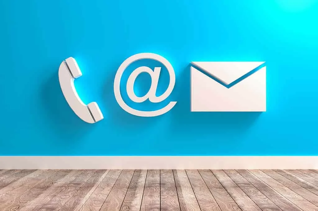 Wall with white icons of a phone, at symbol, and envelope on a blue background.