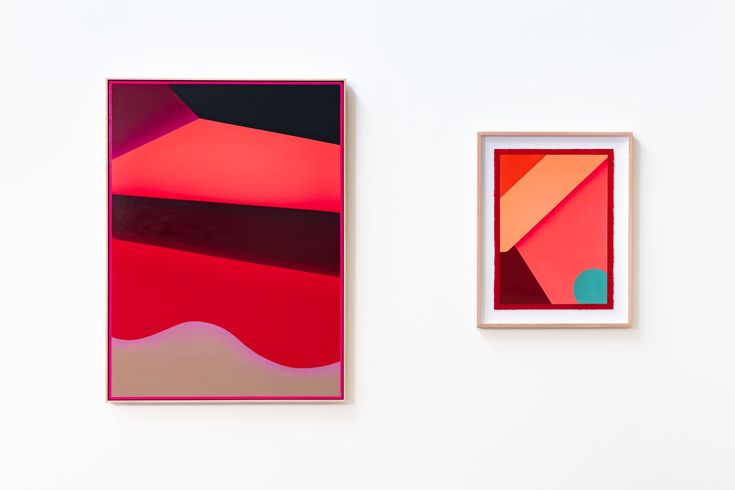 Two colorful abstract paintings hanging on a white gallery wall.