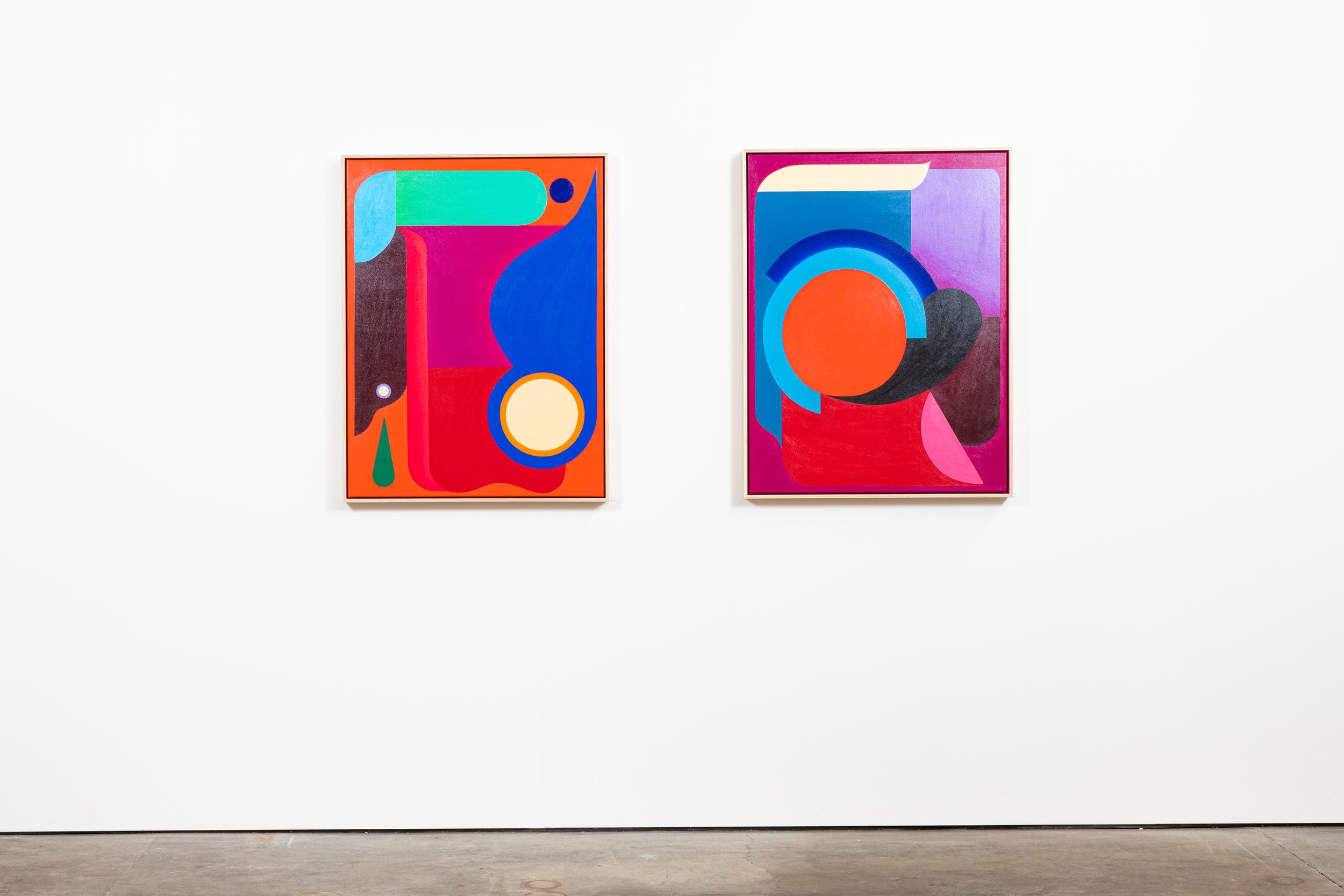 Two abstract colorful paintings hanging on a white gallery wall.