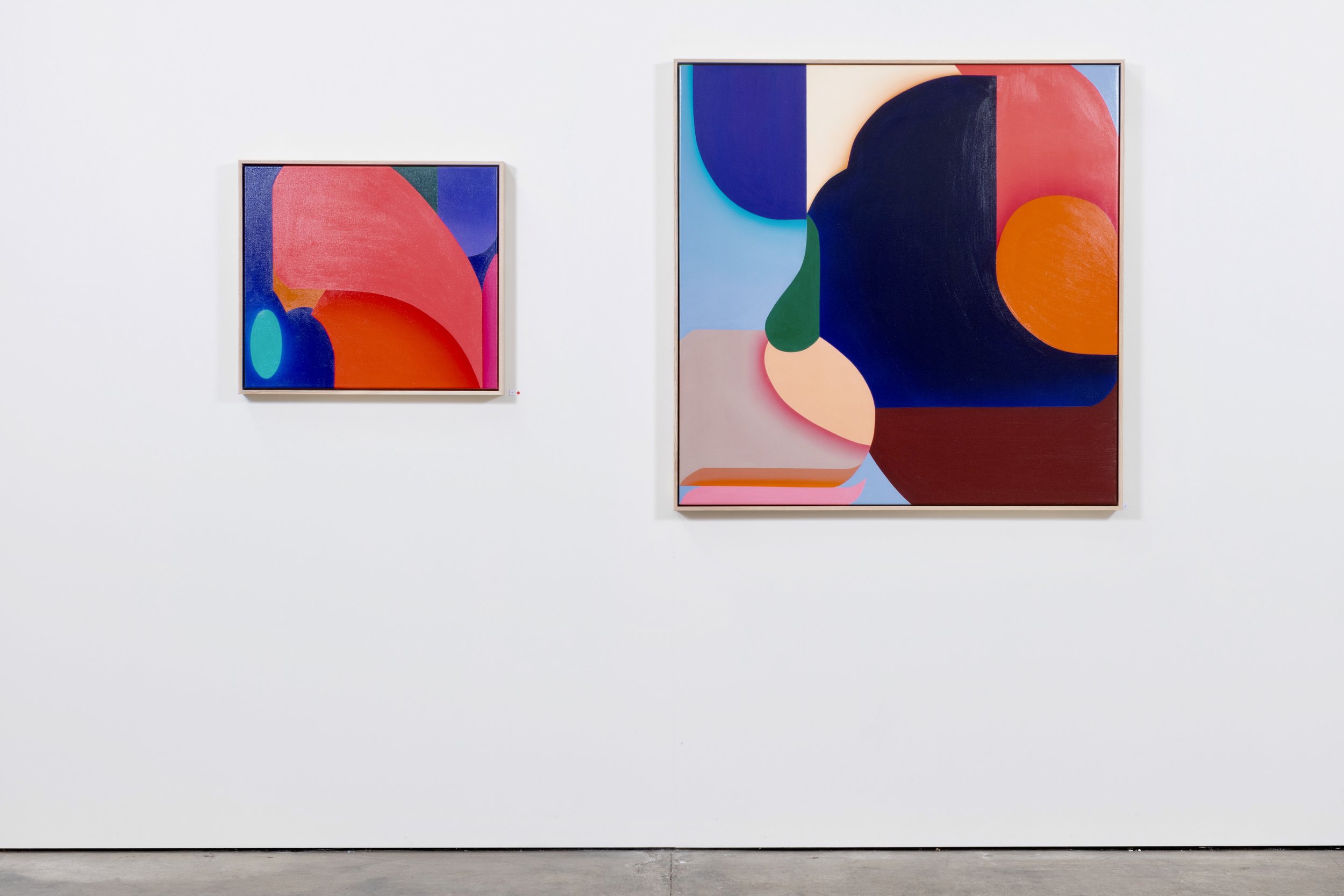 Two abstract colorful paintings hanging on a white gallery wall.