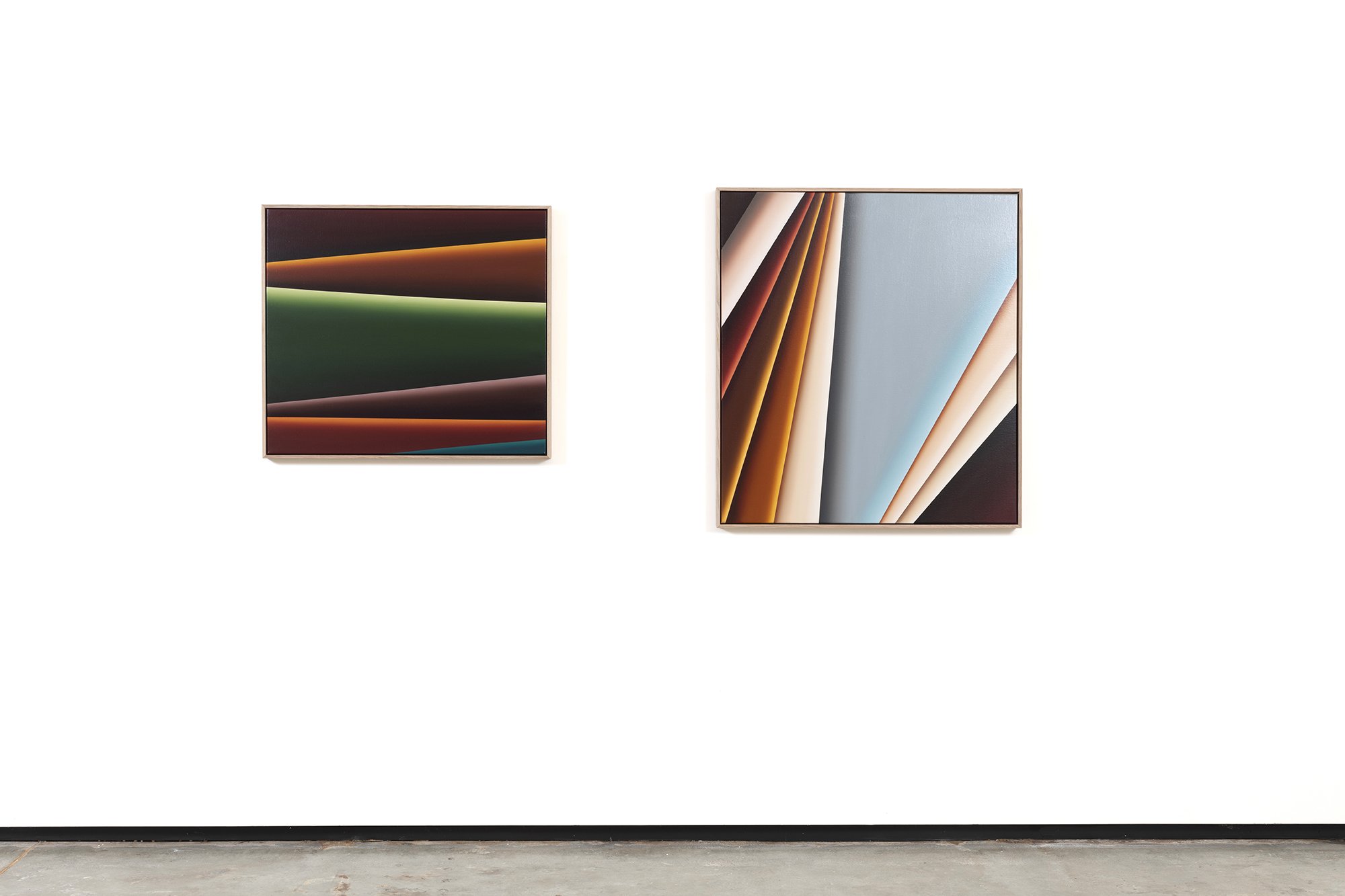 Two abstract artworks on a white gallery wall