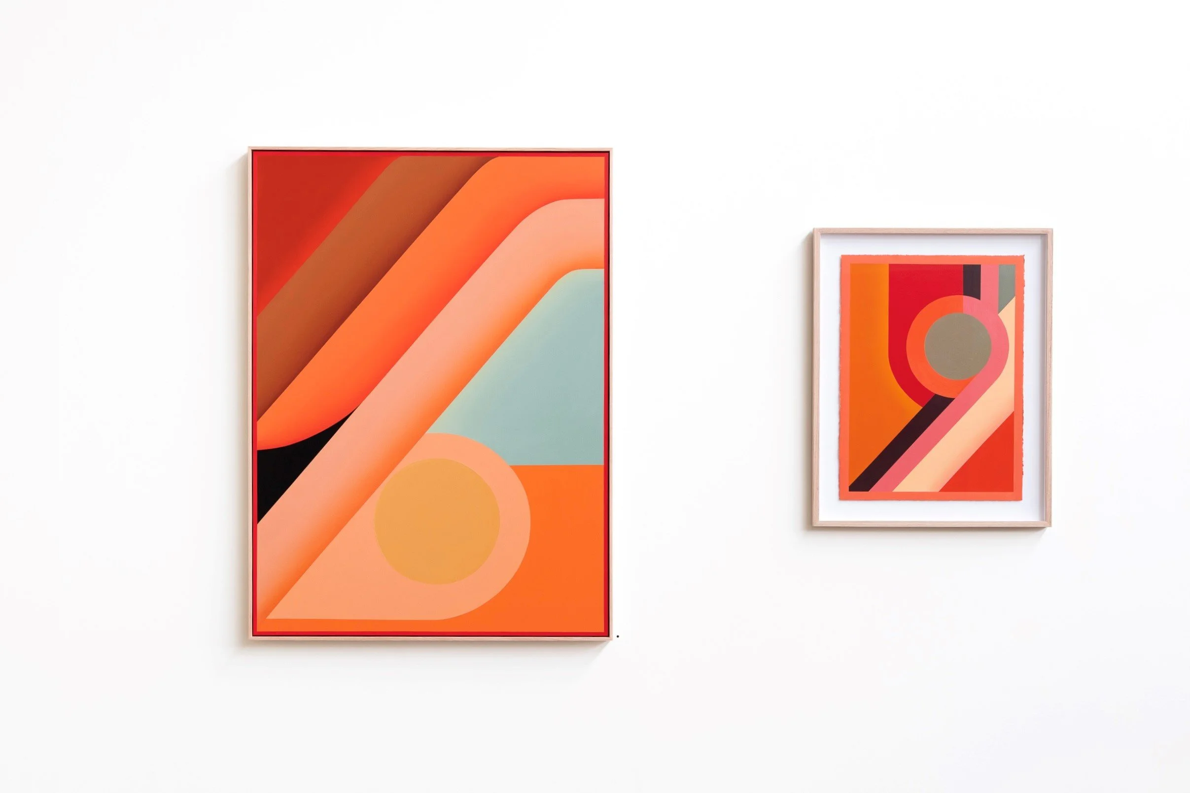 Two abstract geometric art pieces hanging on a white wall, featuring bold colors such as orange, red, black, and beige with various shapes and lines.
