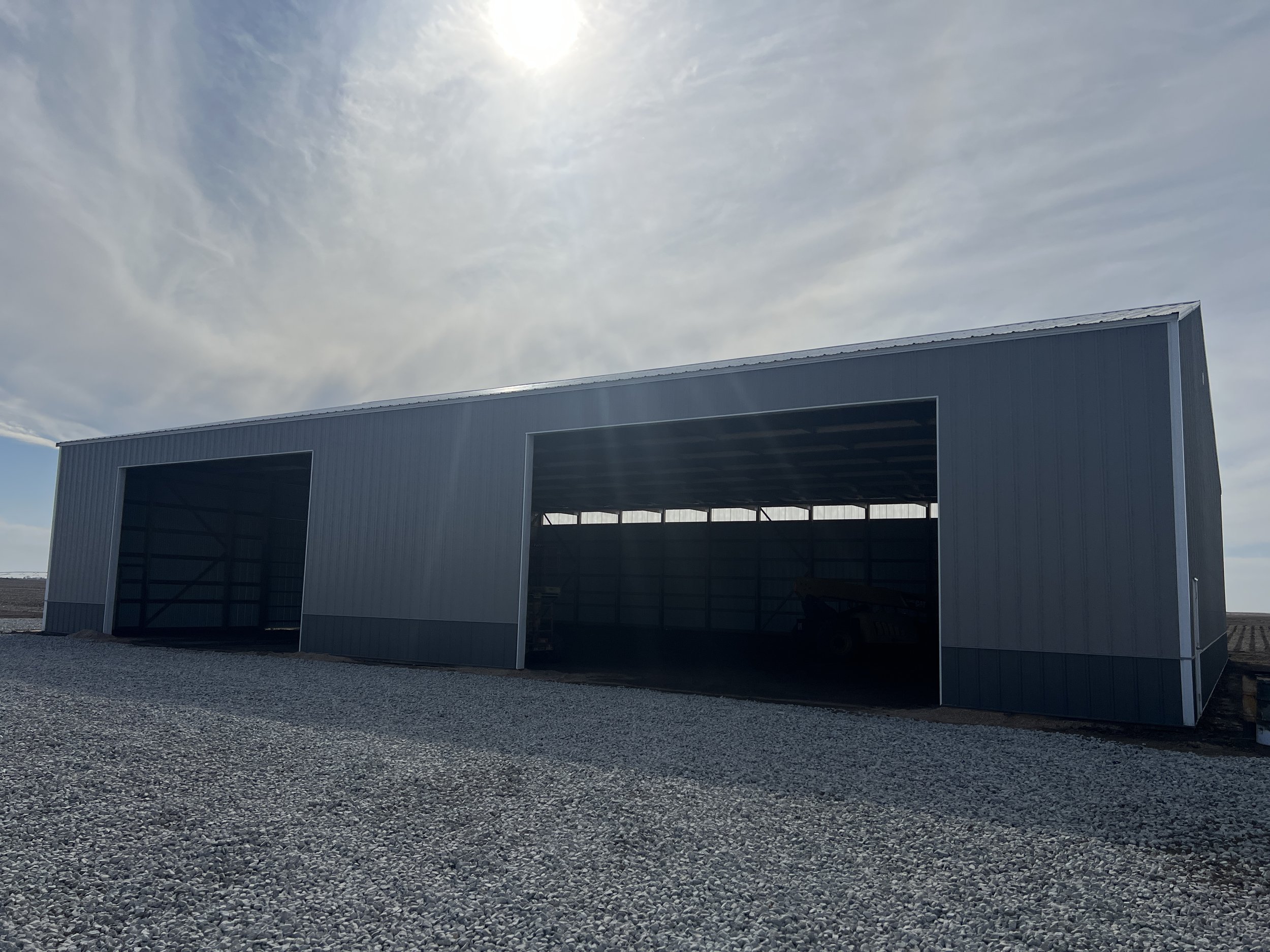 Large Agricultural Post frame 80'x100' with two large overhead door with grey wainscot located in Fairmont, Nebraska