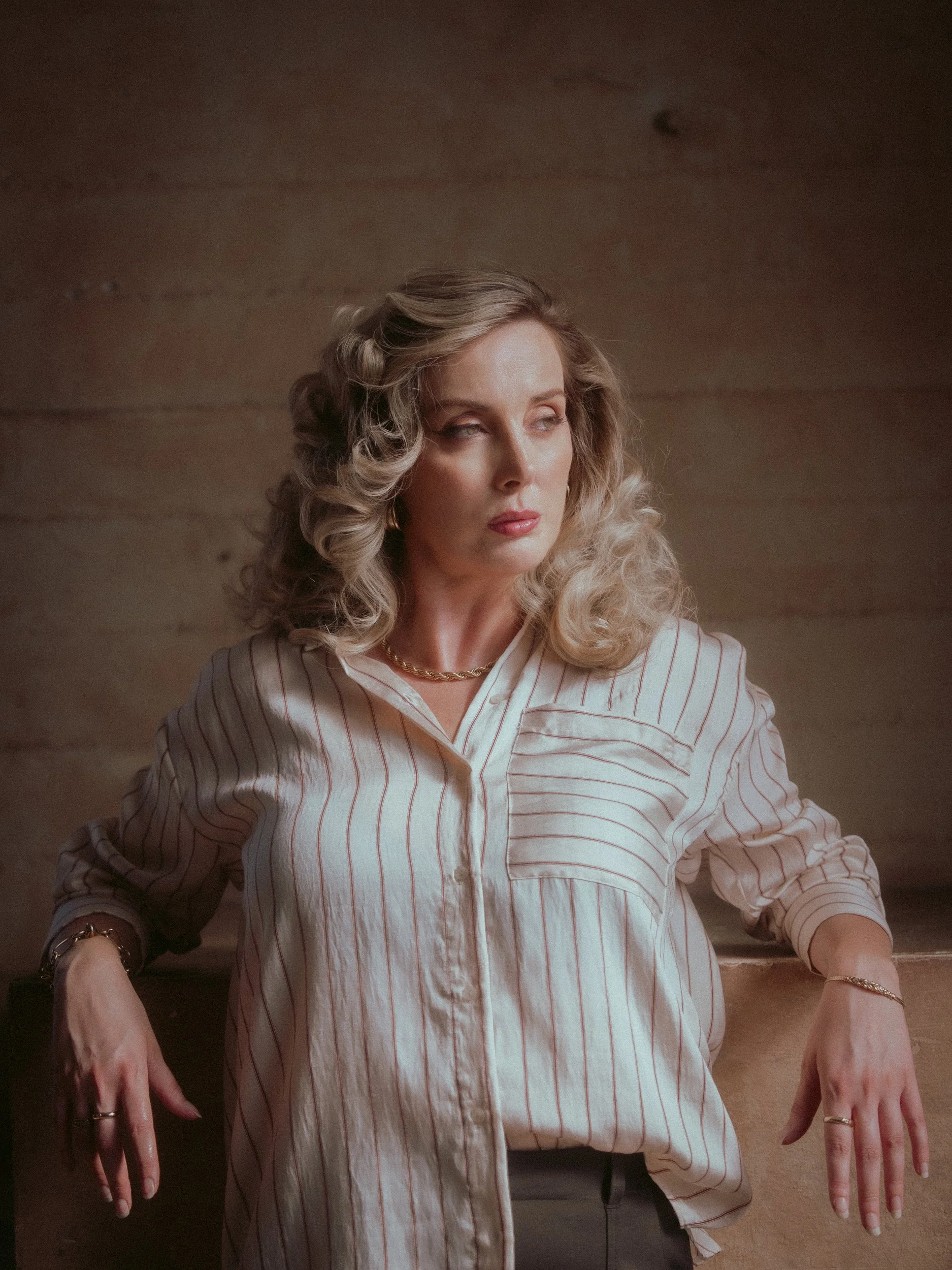 Seated portrait of Milanka Brooks in a striped shirt, editorial fashion photography by Osy Ikhile, Los Angeles