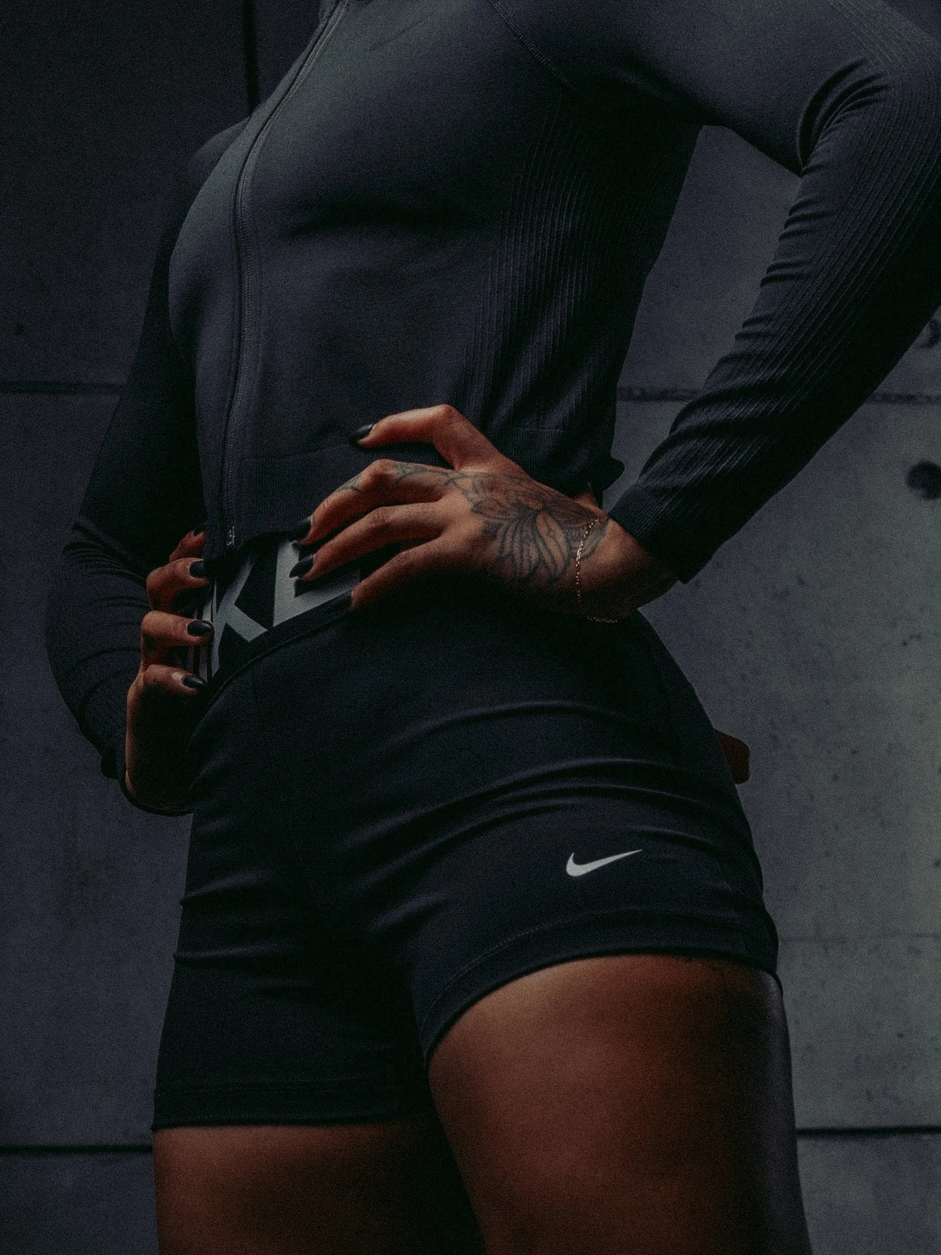 Close-up of Nike shorts and a long-sleeve training top, hands on hips