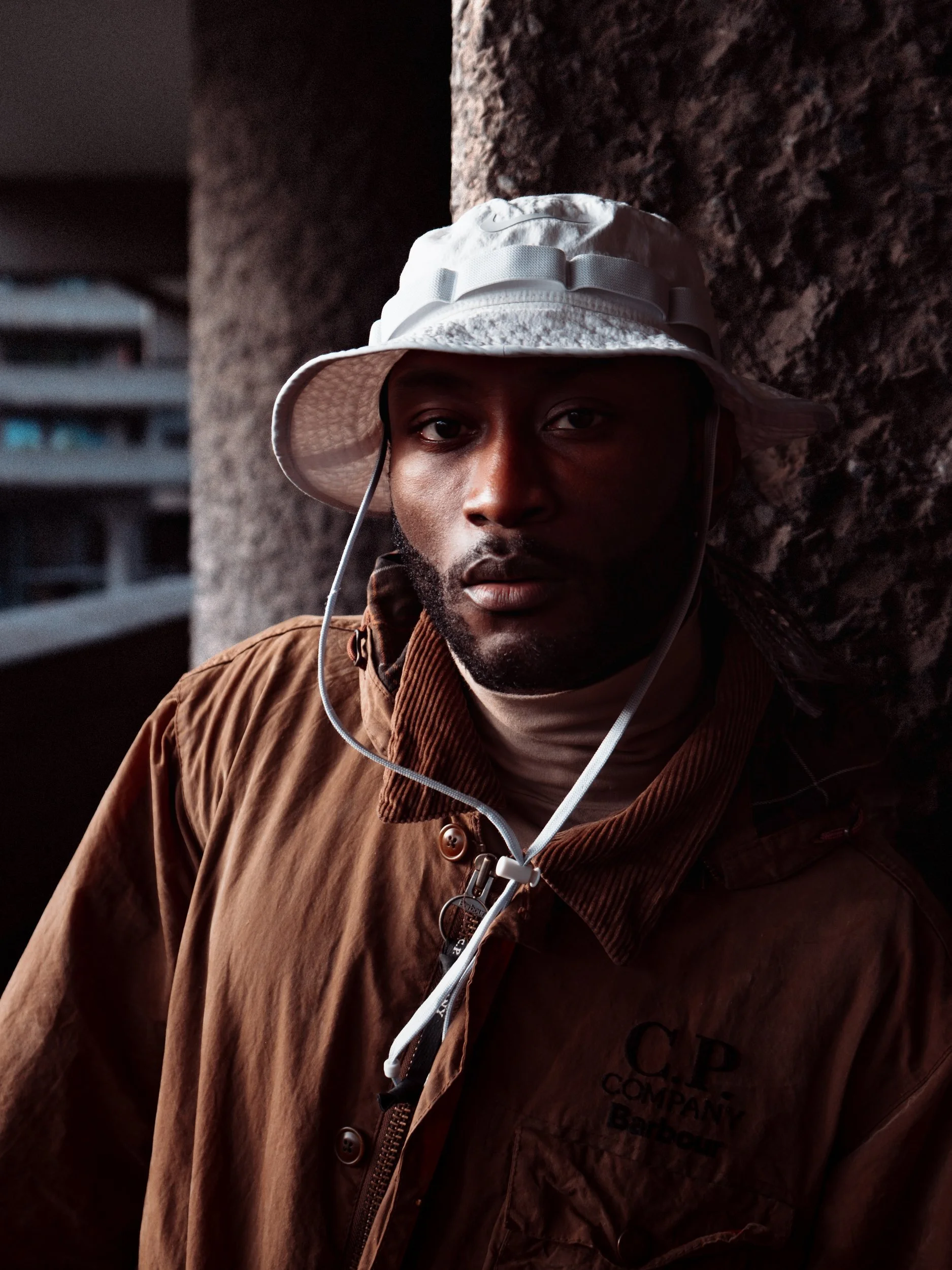 Close-up of Paul Bossman in a bucket hat and brown C.P. Company jacket