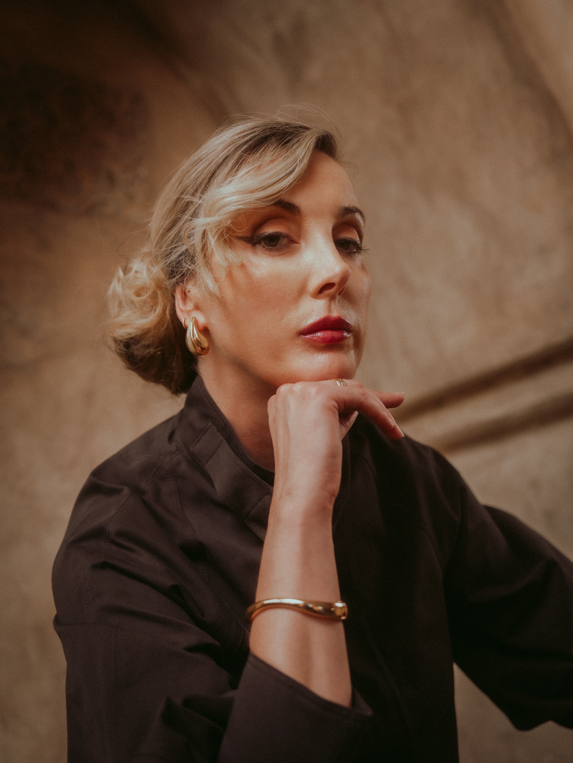 Milanka Brooks portrait, chin resting on her hand, gold cuff, editorial fashion photography by Osy Ikhile, Los Angeles