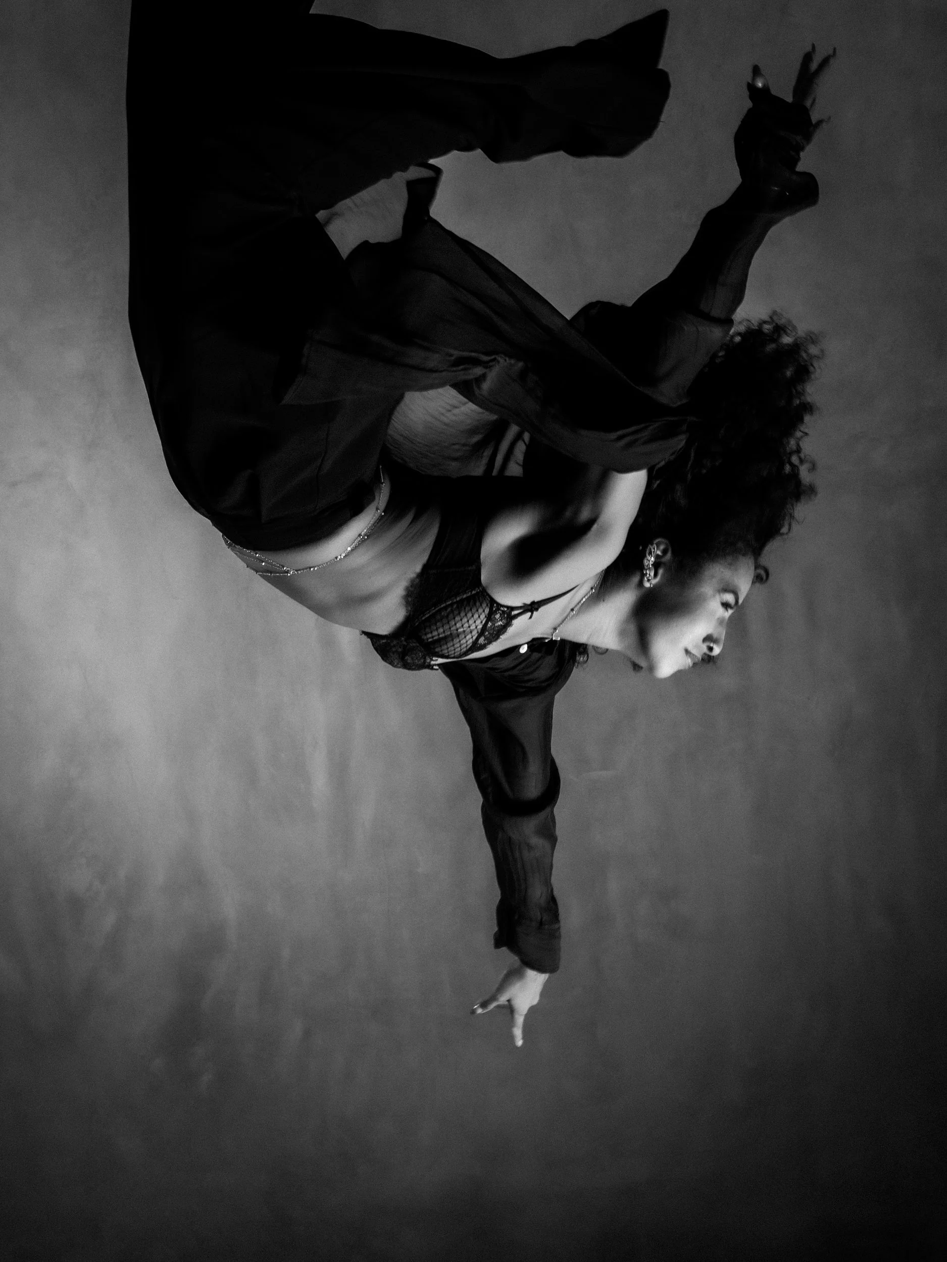 Mirna Moreno upside down mid-move against a grey wall