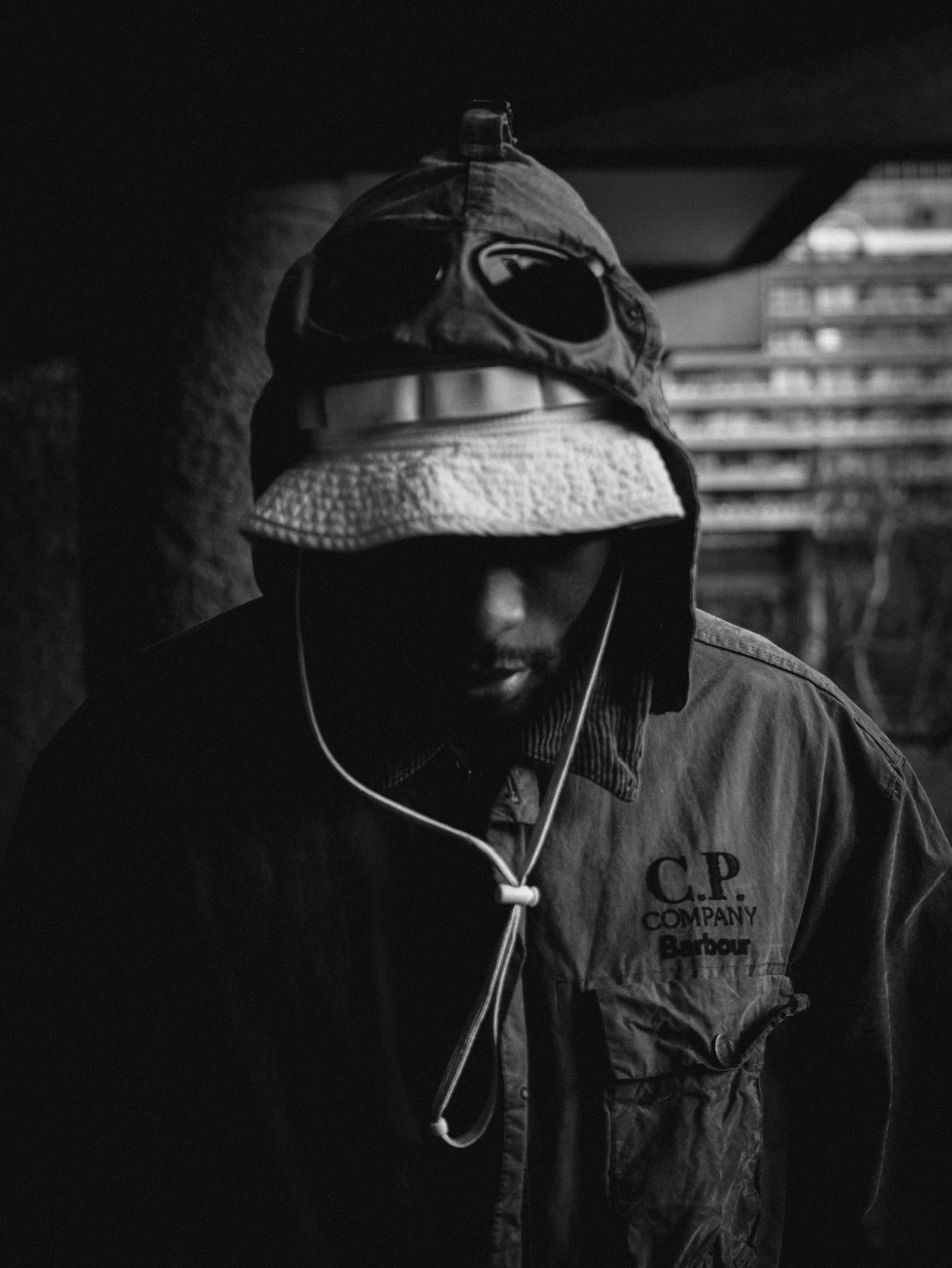 Paul Bossman in a C.P. Company goggle hood, black and white