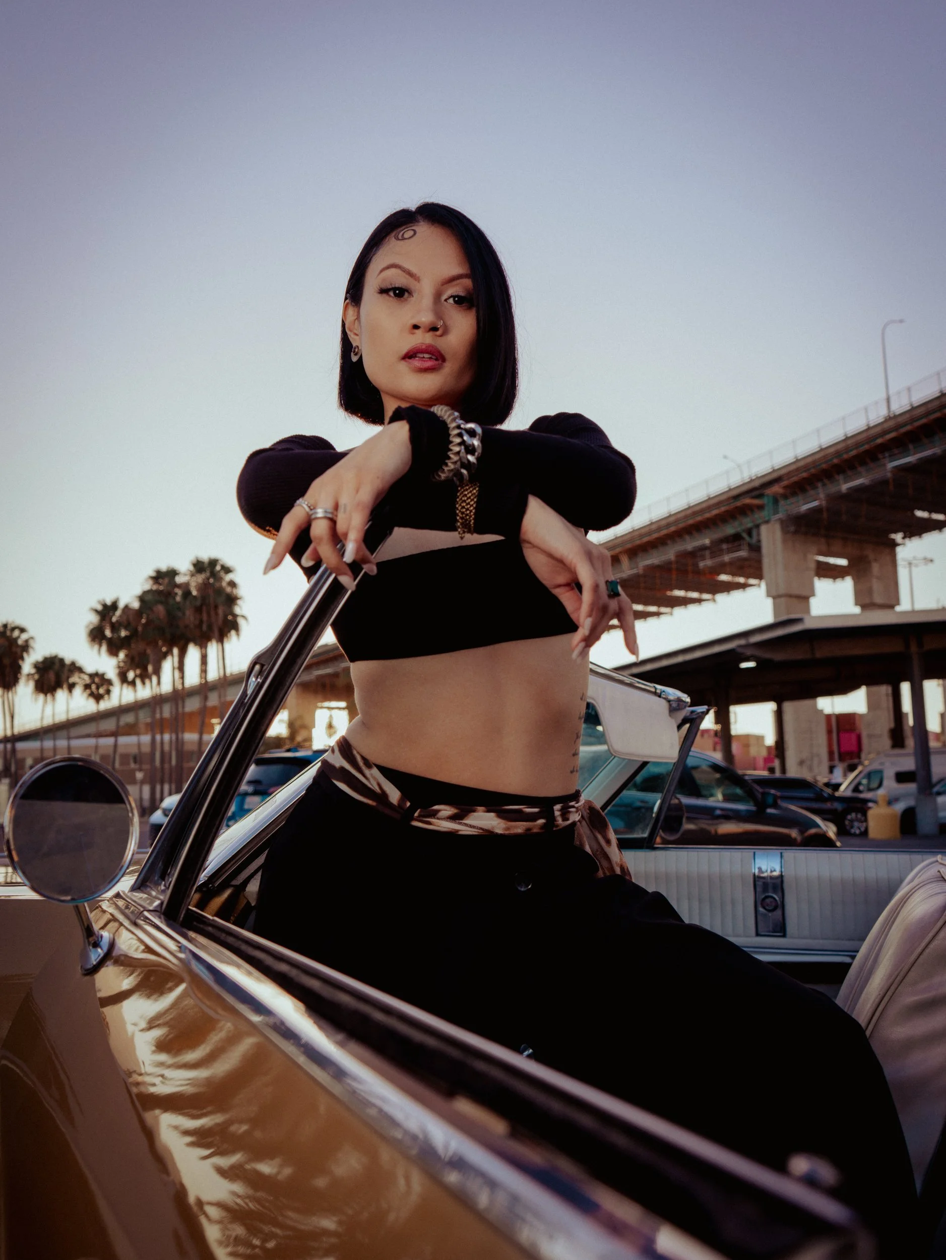 Shaina Rae in the open door of a vintage lowrider