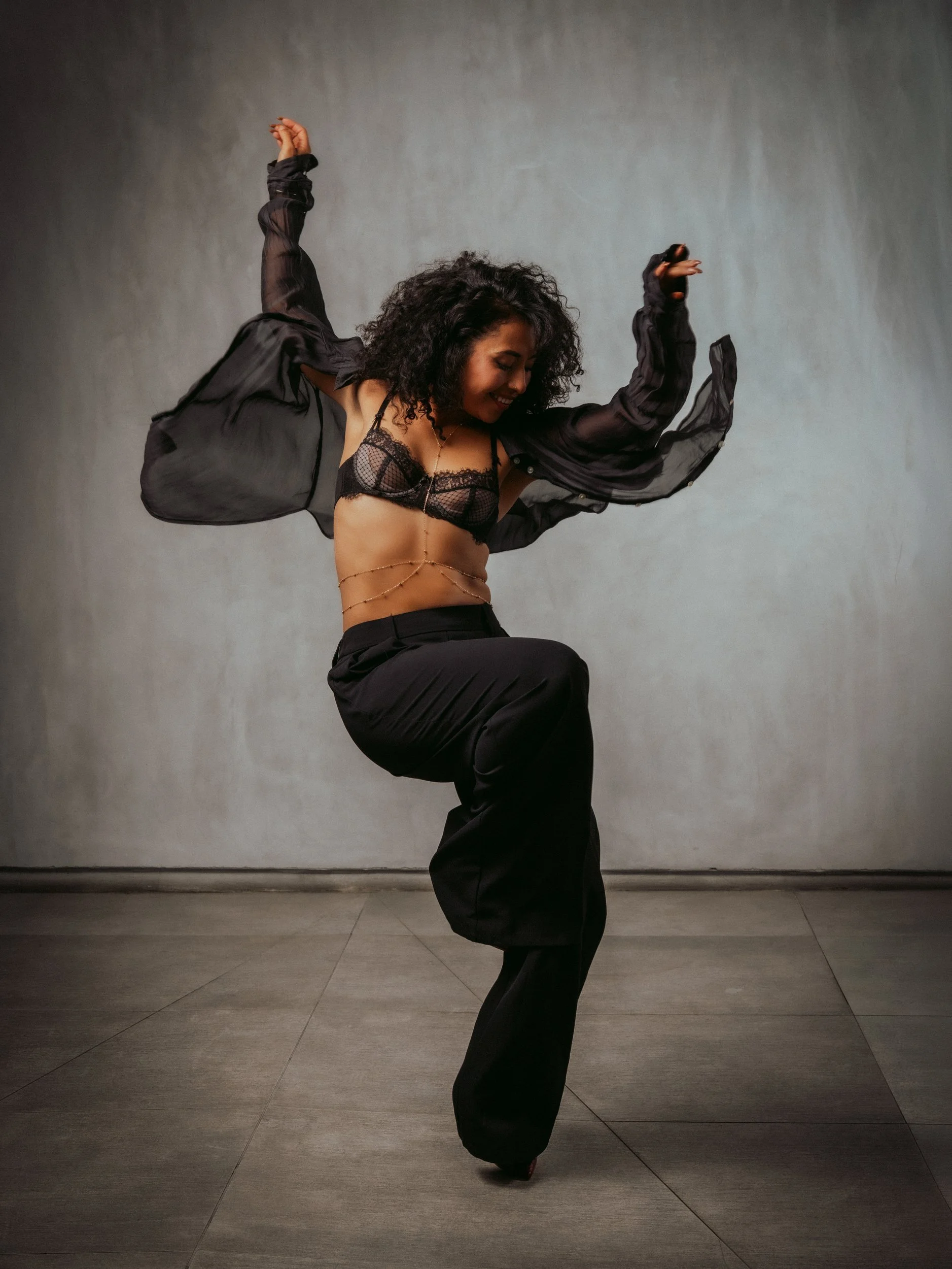 Mirna Moreno dancing in a sheer black shirt and wide trousers, the image used on the Luxira magazine cover