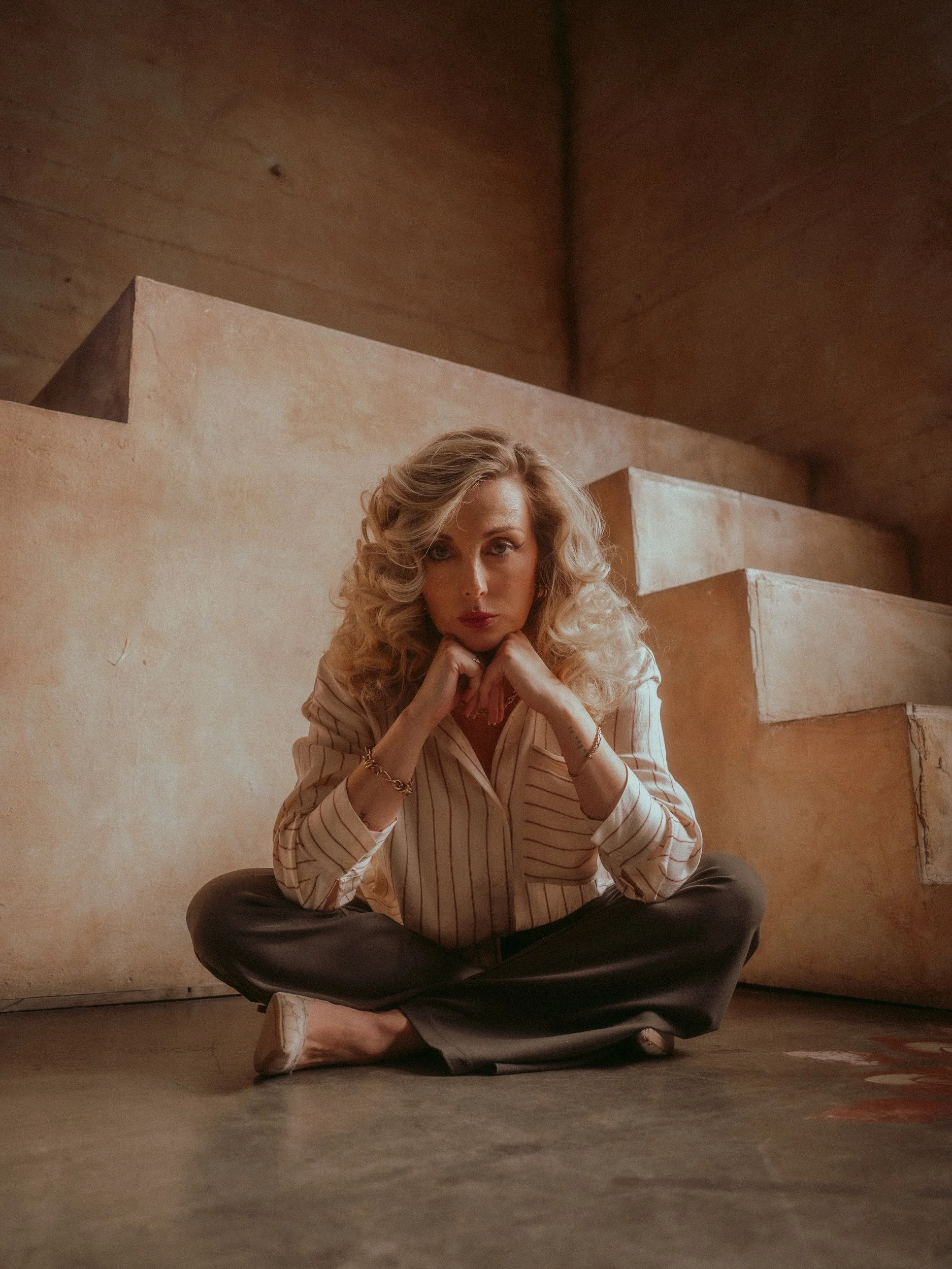 Milanka Brooks seated cross-legged on the floor by the stairs, editorial fashion photography by Osy Ikhile, Los Angeles
