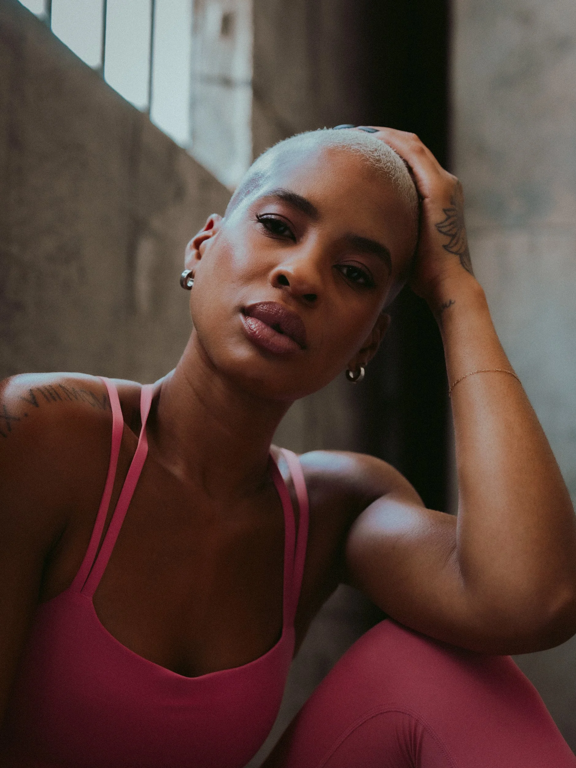 Portrait of an athlete in a pink sports bra with her hand on her head